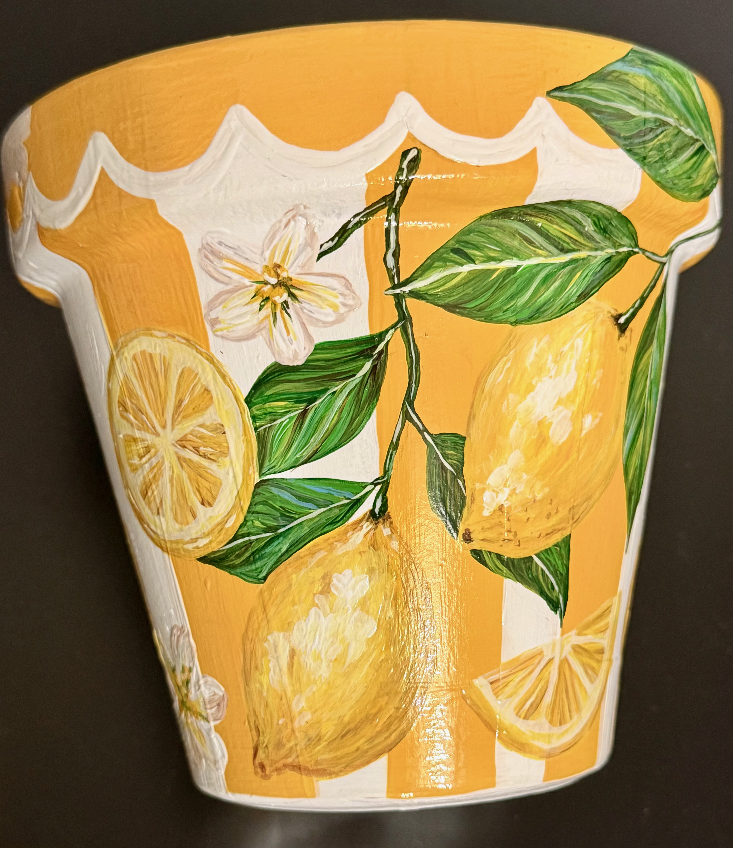 Decorative ceramic cup featuring a painted lemon slice, green leaves, a white flower, and a bright yellow background with a white border design.