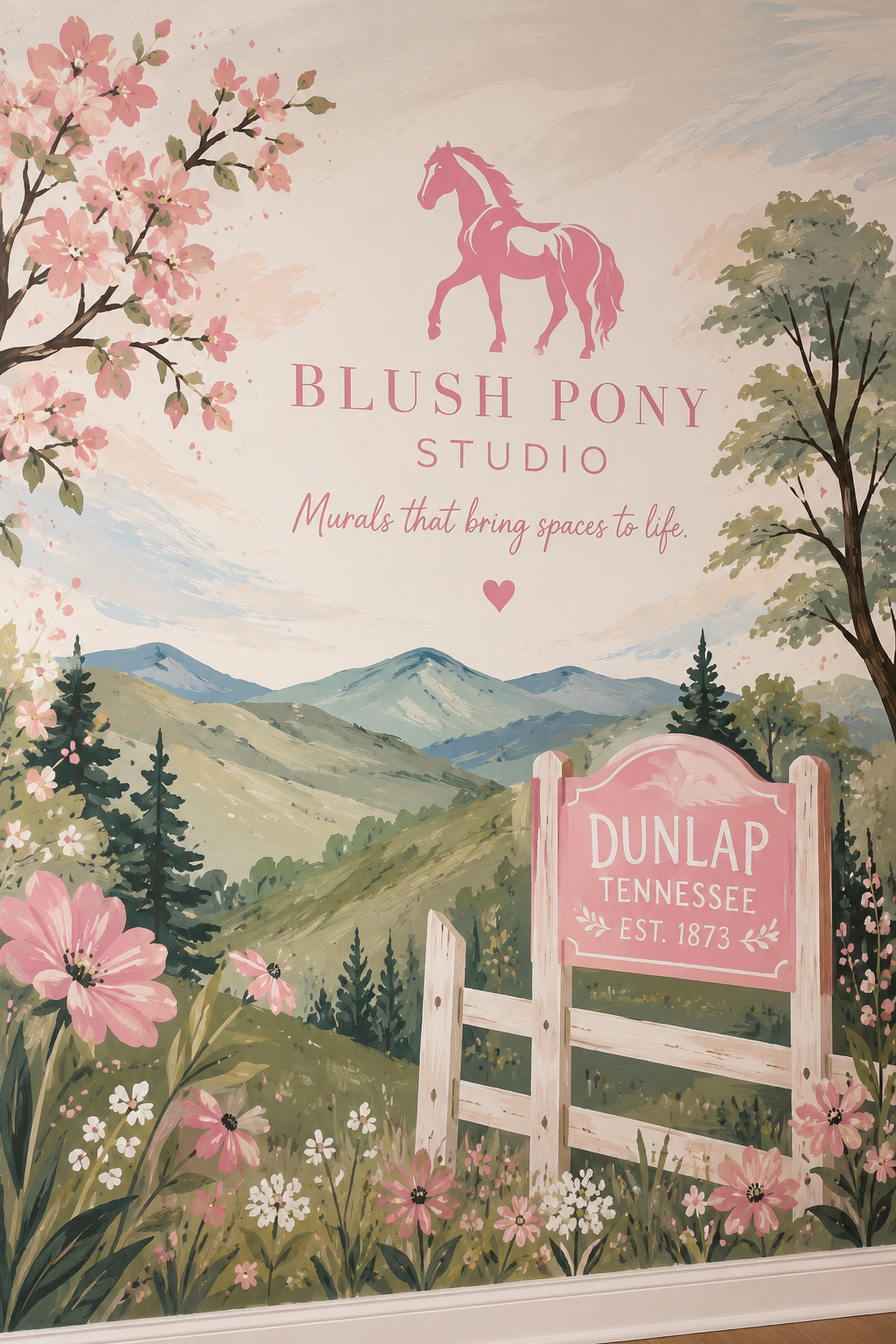 A mural of a scenic mountain landscape with pink flowers and trees, featuring the text 'Blush Pony Studio' with a pink pony logo, a tagline 'Murals that bring spaces to life,' and a pink sign that reads 'Dunlap Tennessee Est. 1873.'