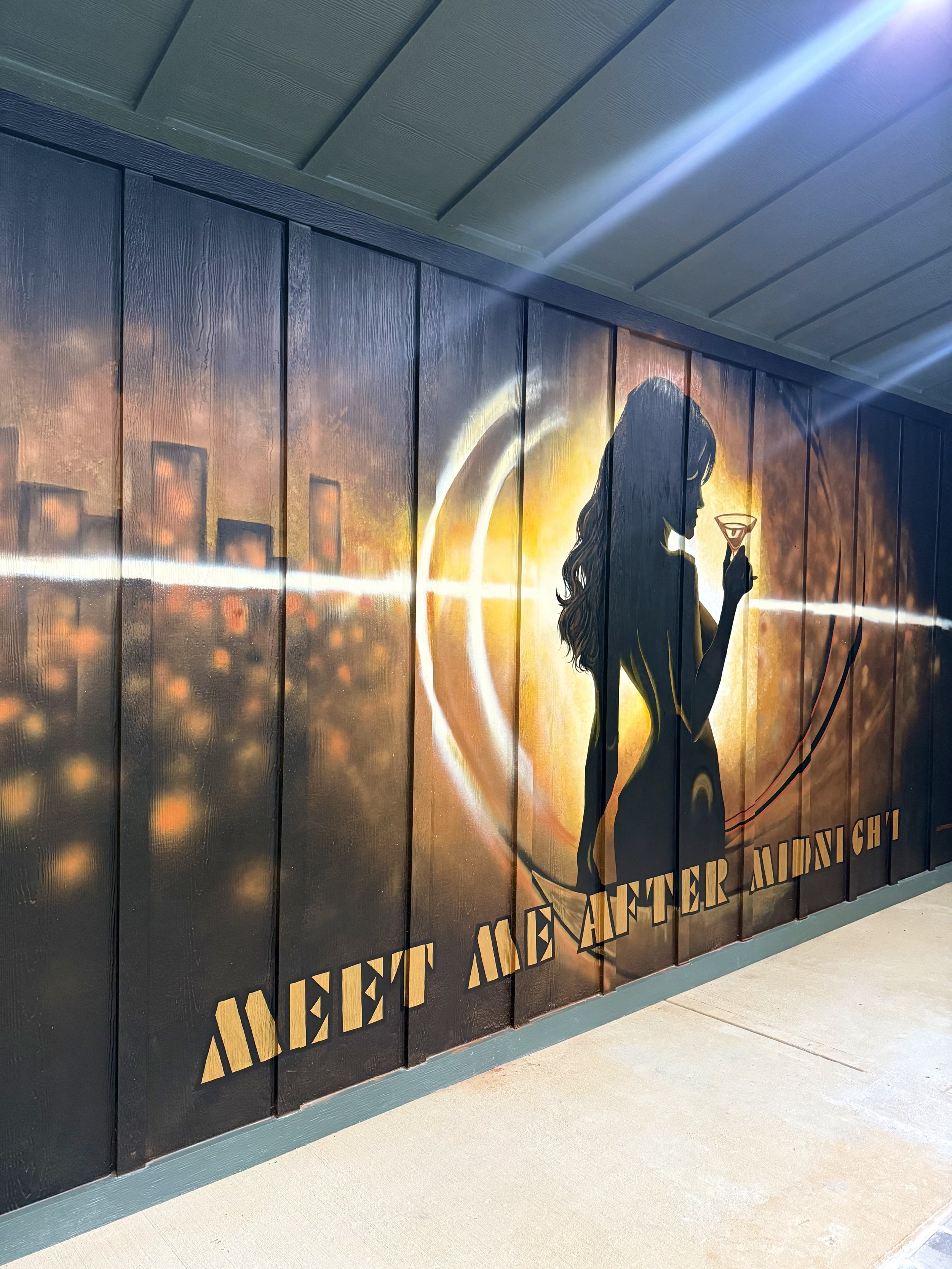 Wall mural featuring the silhouette of a woman holding a martini glass, with cityscape and sunset background, and the text "Event After Midnight".
