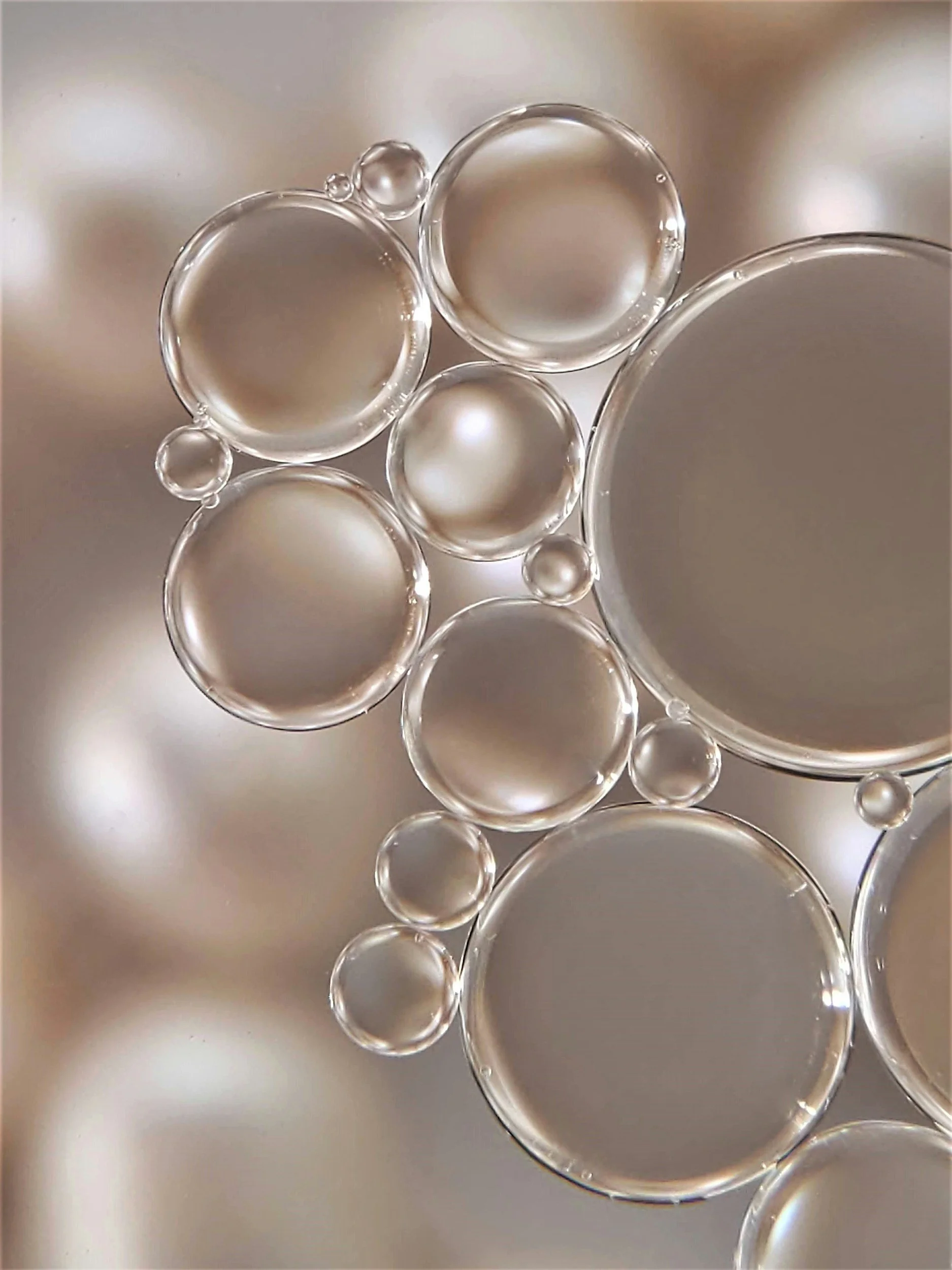 Close-up view of bokeh bubbles or glass spheres on a soft, light background.