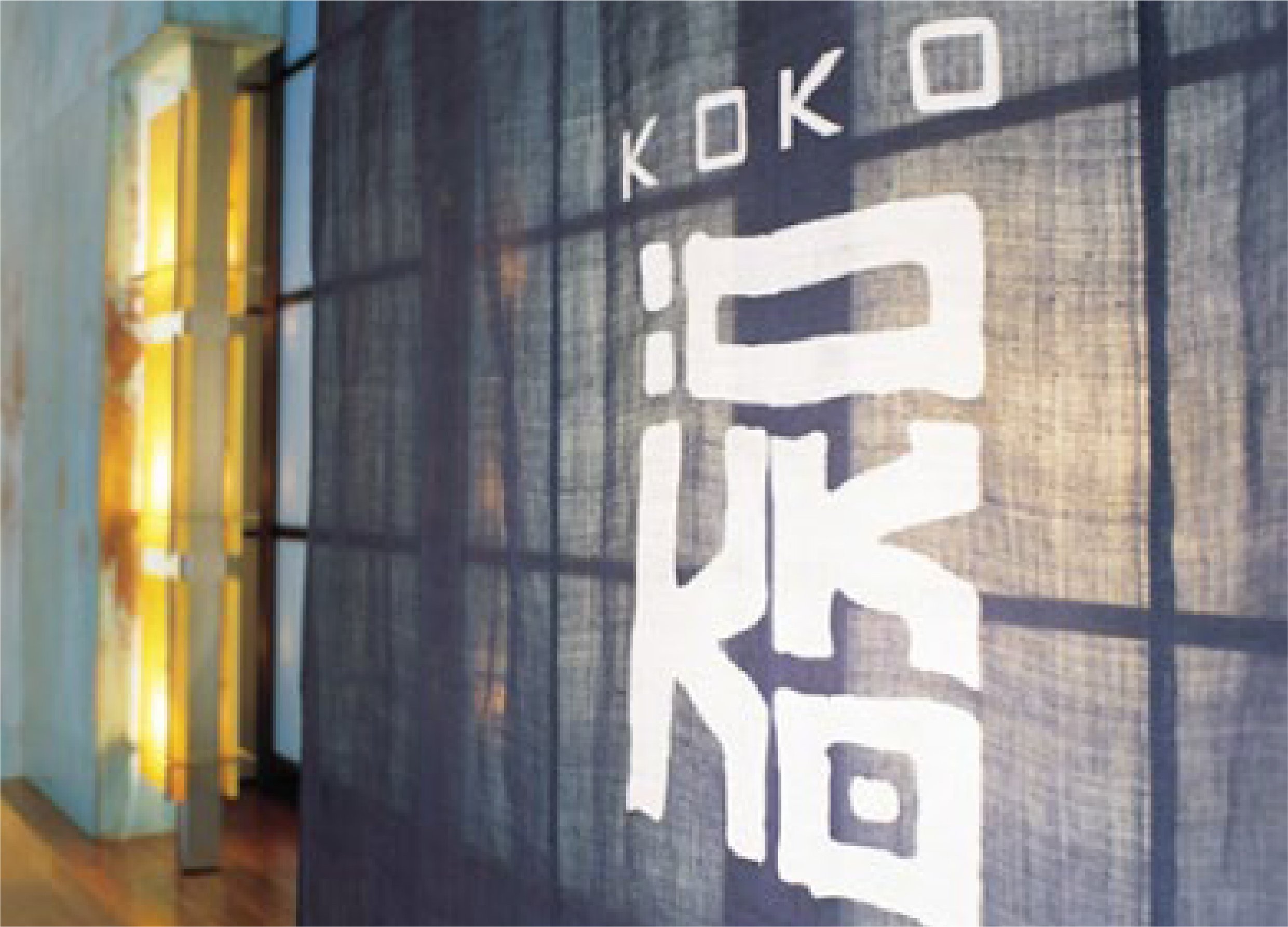 A gym floor with the word 'KOKO' painted in large white letters, and a pair of slippers placed near the words.