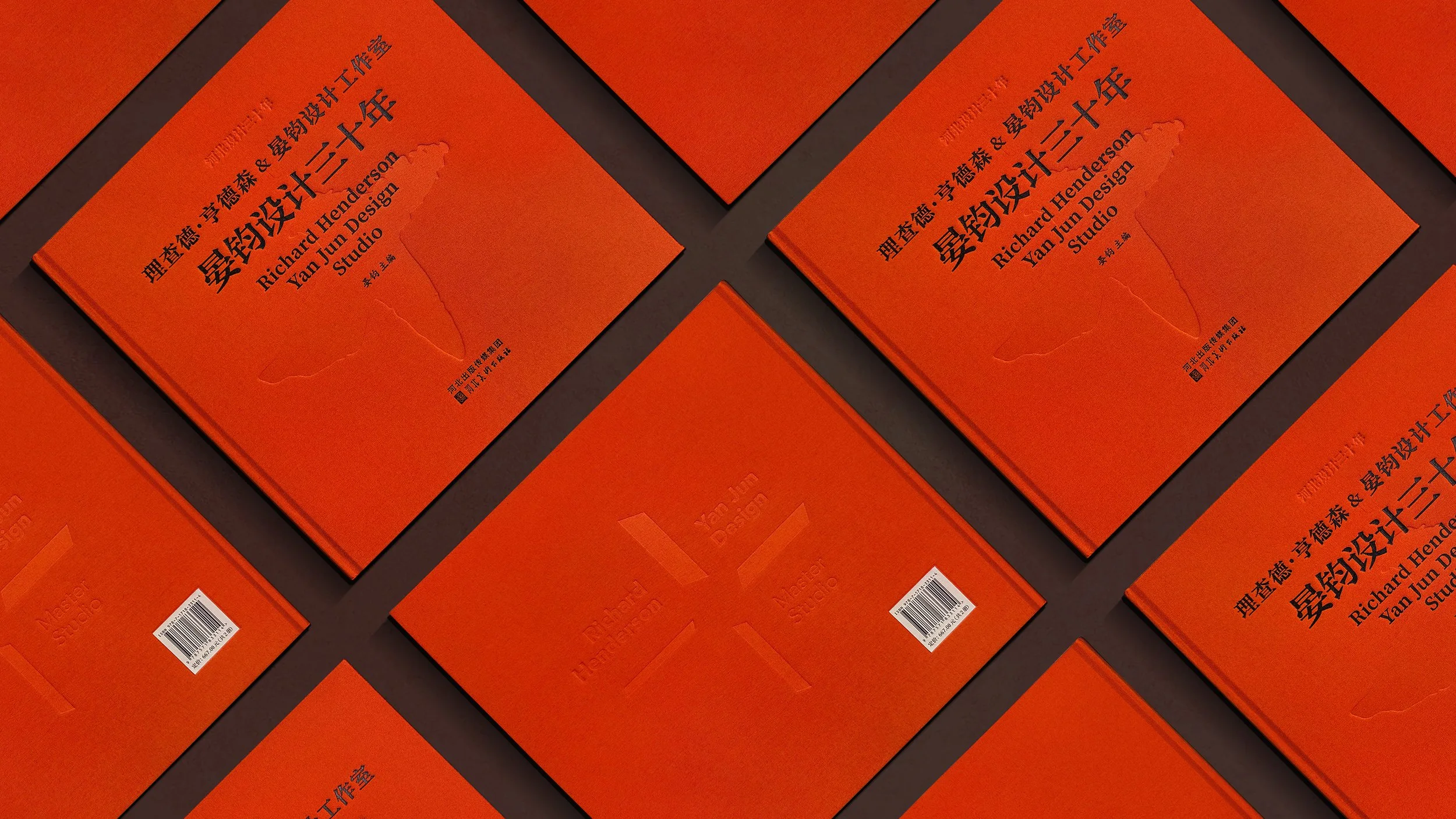 Multiple copies of an orange book titled 'Design Studio' by Richard Henderson and Yan Jun Design, arranged in an overlapping pattern on a dark surface.
