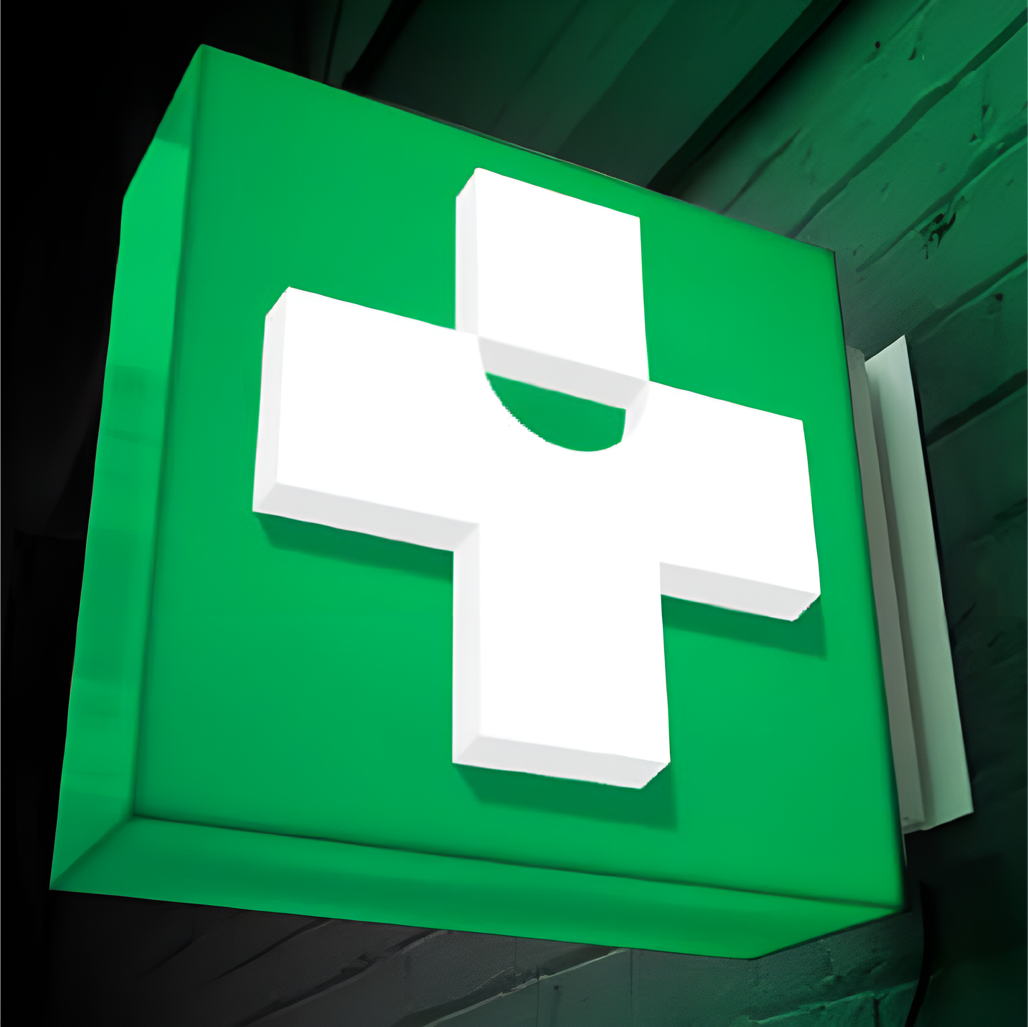 Close-up photo of a green pharmacy illuminated sign.
