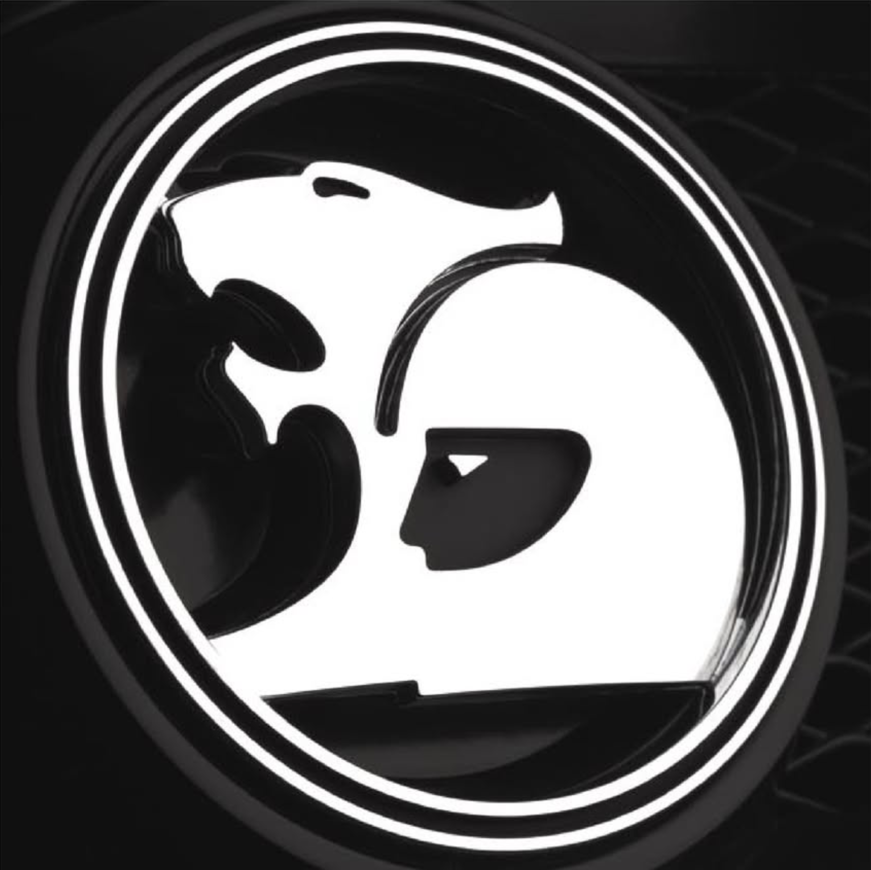 Car emblem featuring a white wolf head silhouette outlined with white light, with a partial circle border on black background.