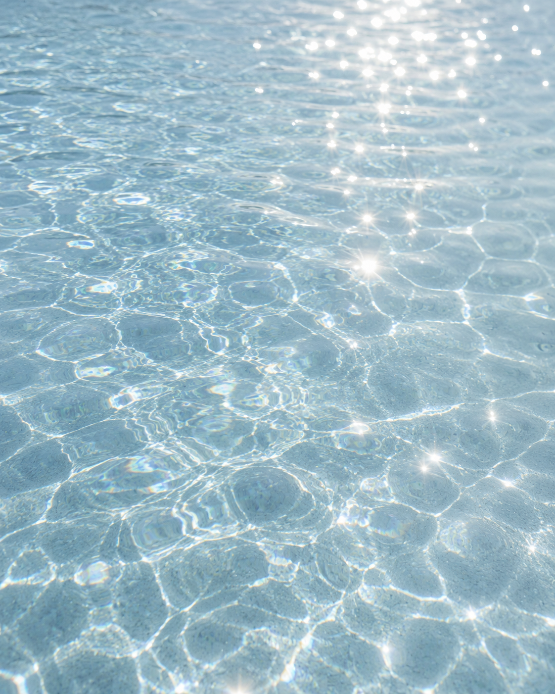 Sunlit clear water with sparkling reflections and gentle ripples.