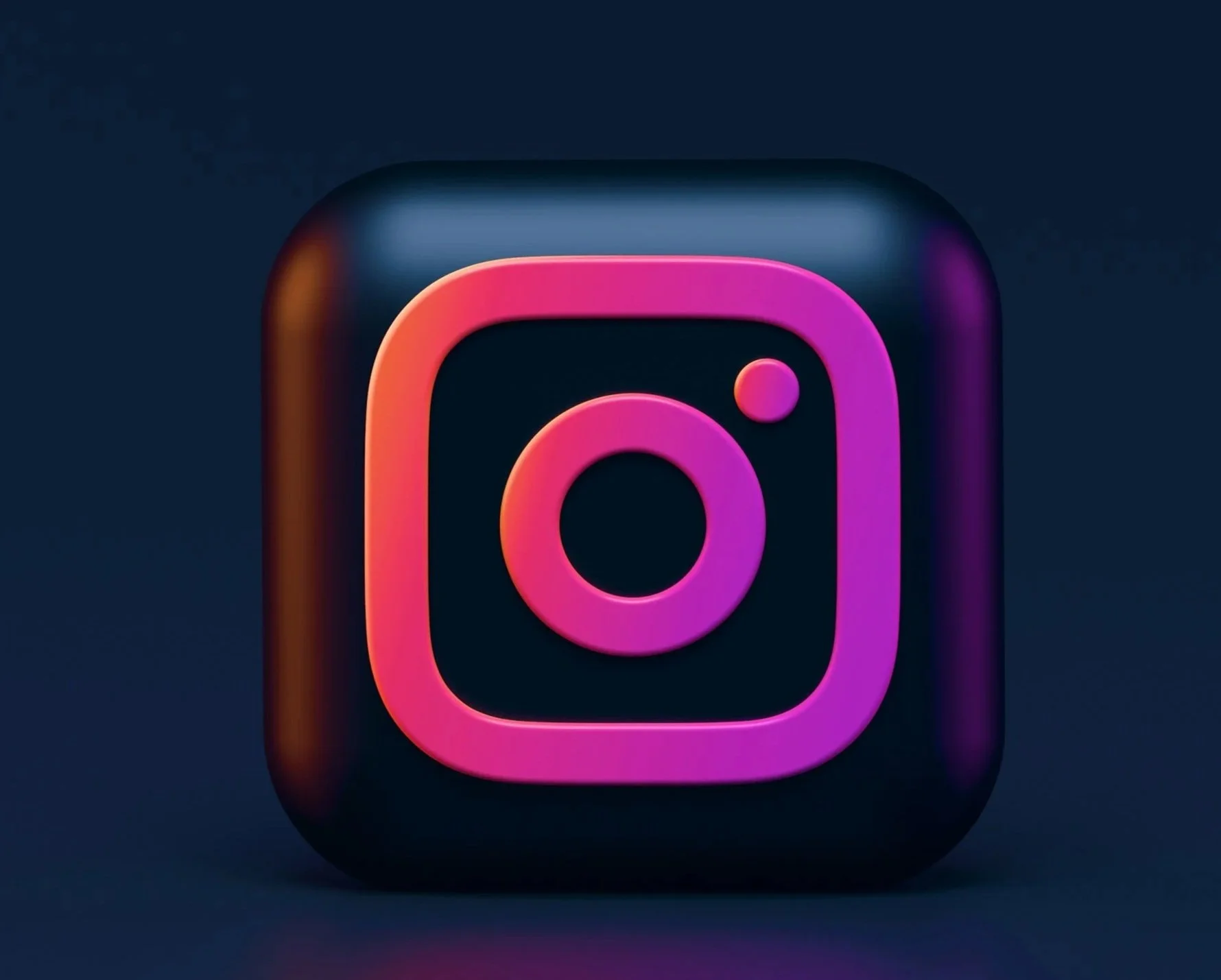 Close-up of a modern, illuminated Instagram app icon with pink and purple accents on a dark background.