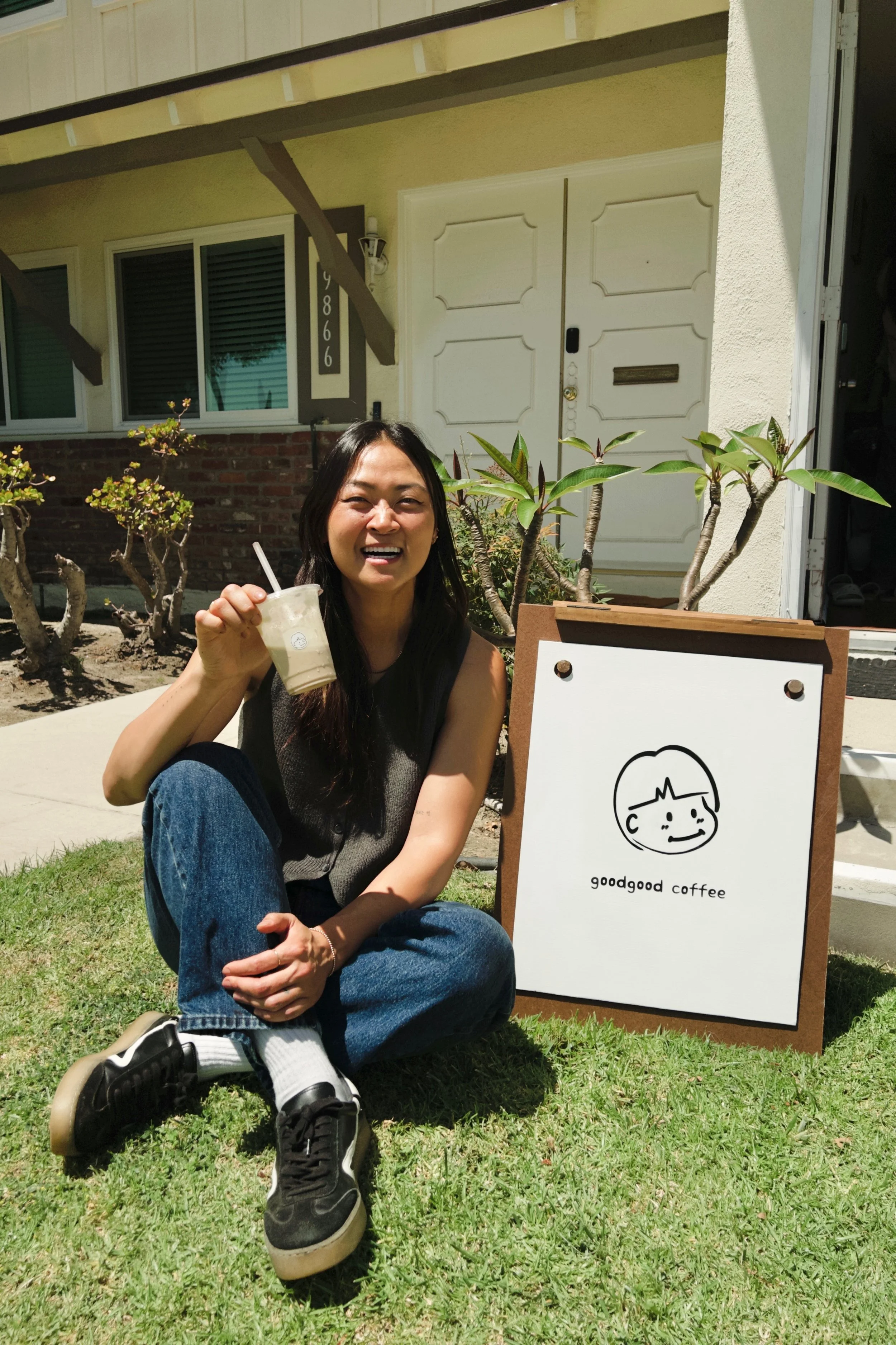 mingie posing in front of the goodgood sign
