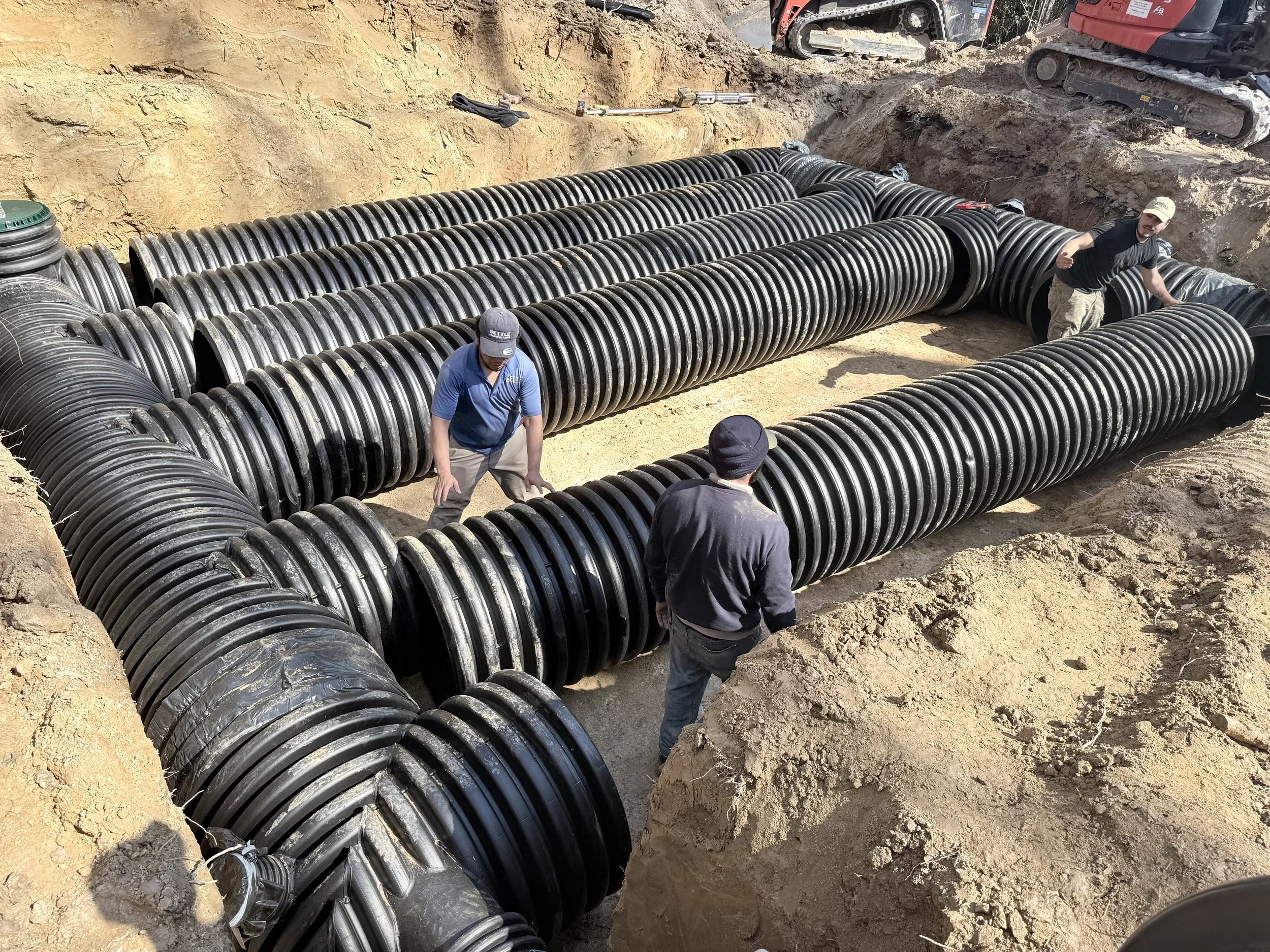 Capital Stormwater crew connecting large-diameter HDPE detention pipes in an open trench during an underground stormwater detention installation in Northern Virginia.