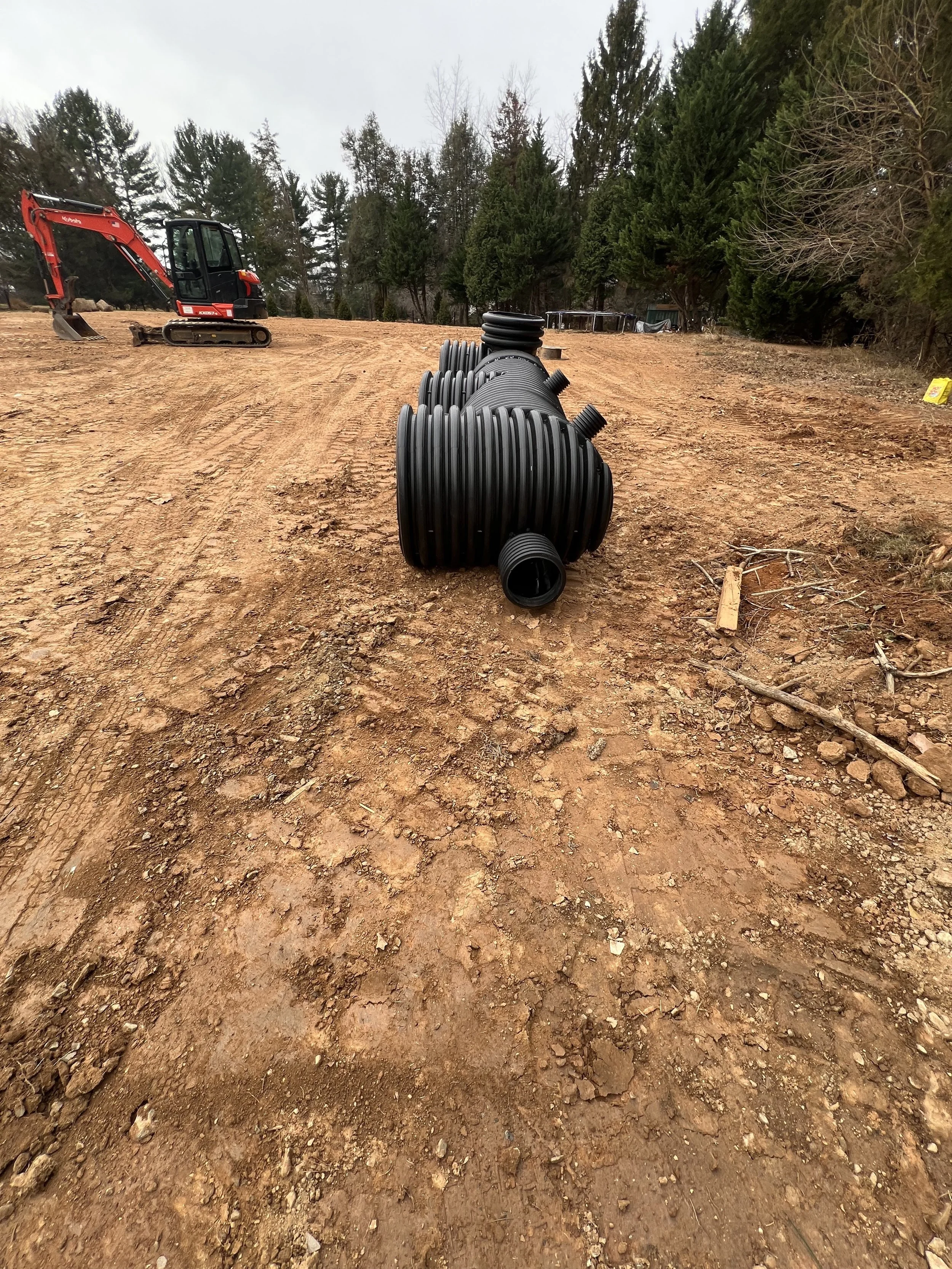 Assembled HDPE stormwater detention manifold staged on a graded lot before burial during an underground detention installation in Northern Virginia.