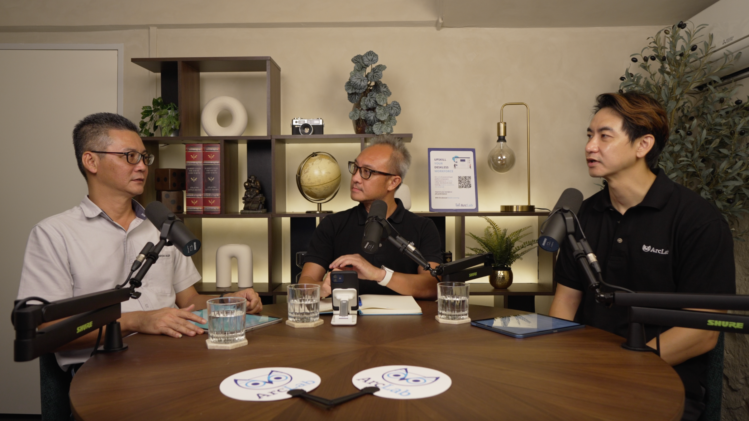 Three-person video podcast recording at Studio Analogue, Singapore, with Shure SM7B mics and the client’s branded signage on set