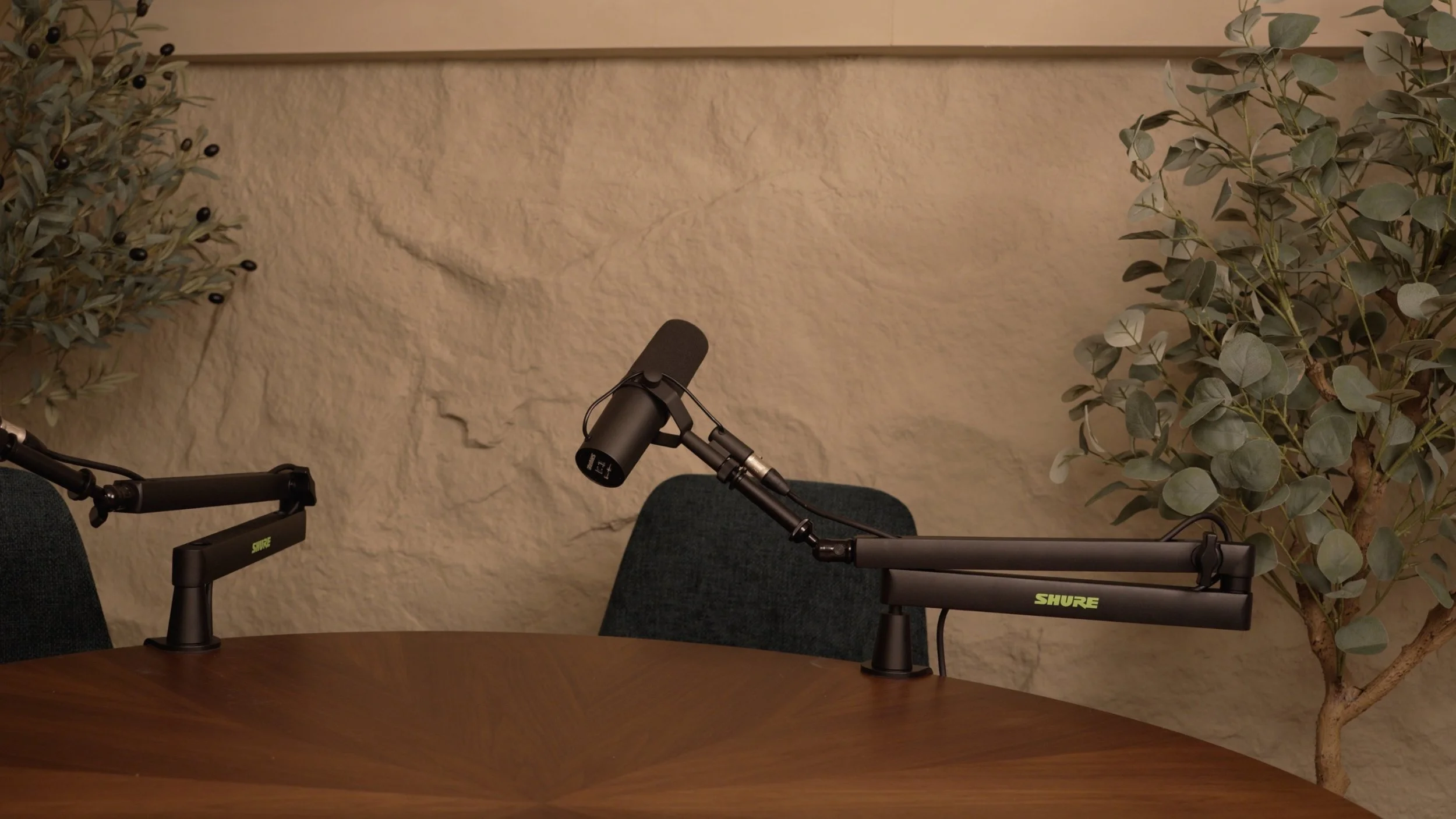 A microphone on a stand positioned in front of a chair, with a table in the foreground at Studio Analogue, a podcast recording studio in Singapore