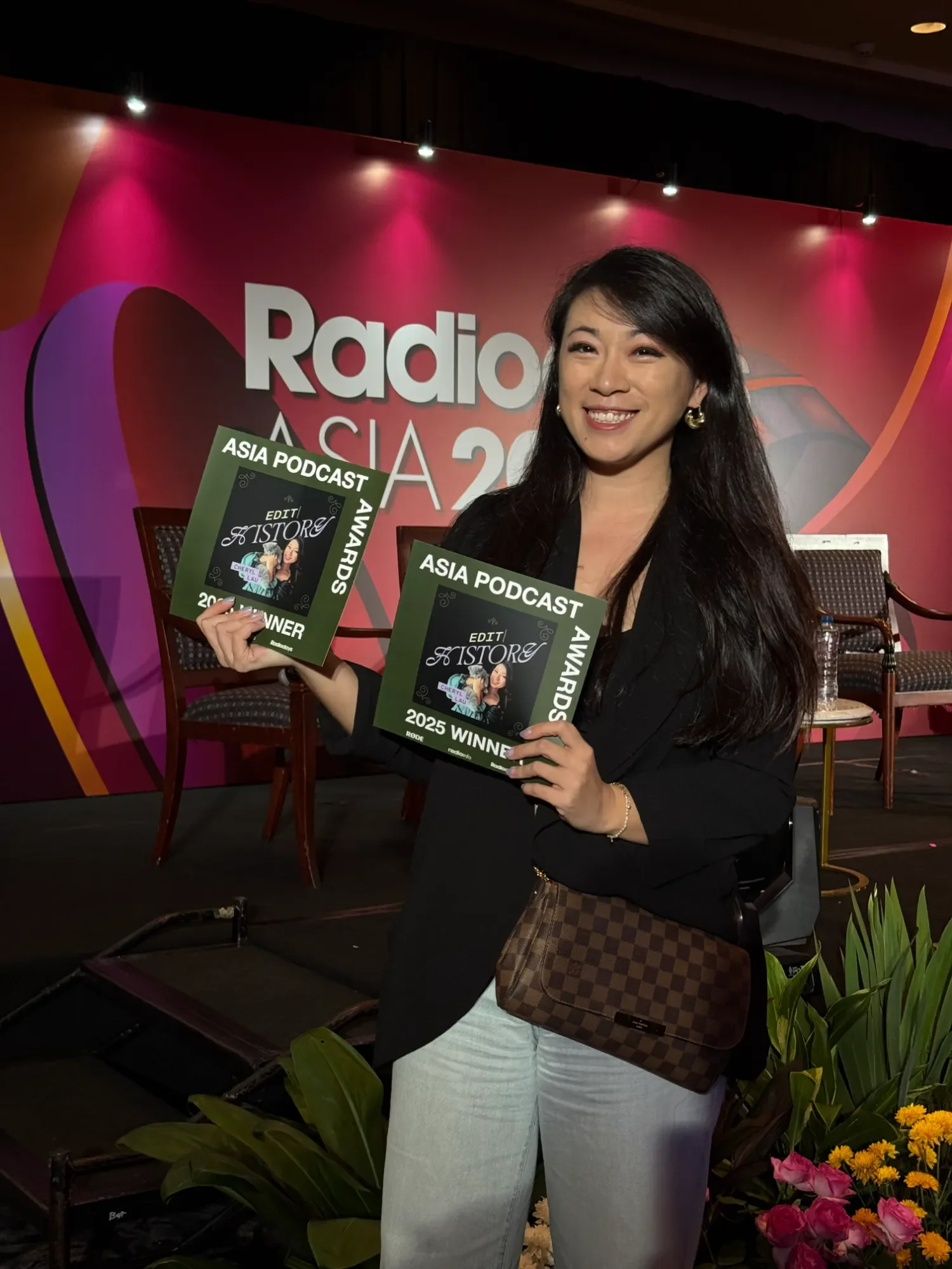 Cheryl Lau, founder of Studio Analogue, holding two awards at the Radio Asia 2025 Awards event.