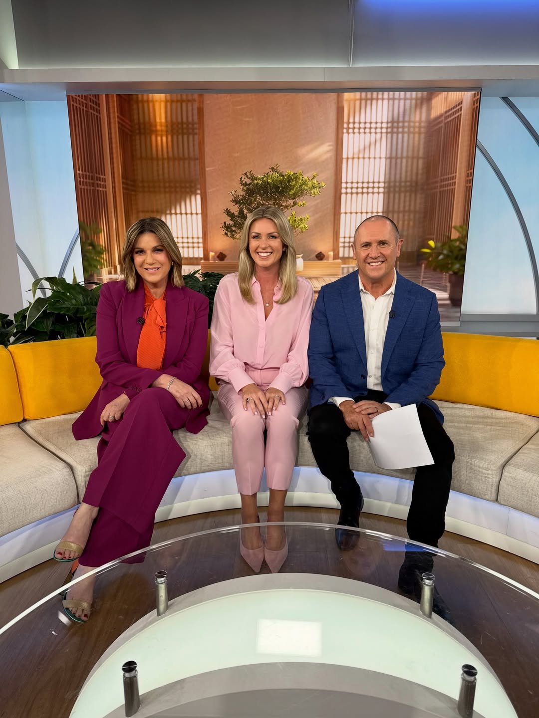 Kimberly Gallagher on set with two TV hosts from The Morning Show sitting together on a curved sofa in studio.