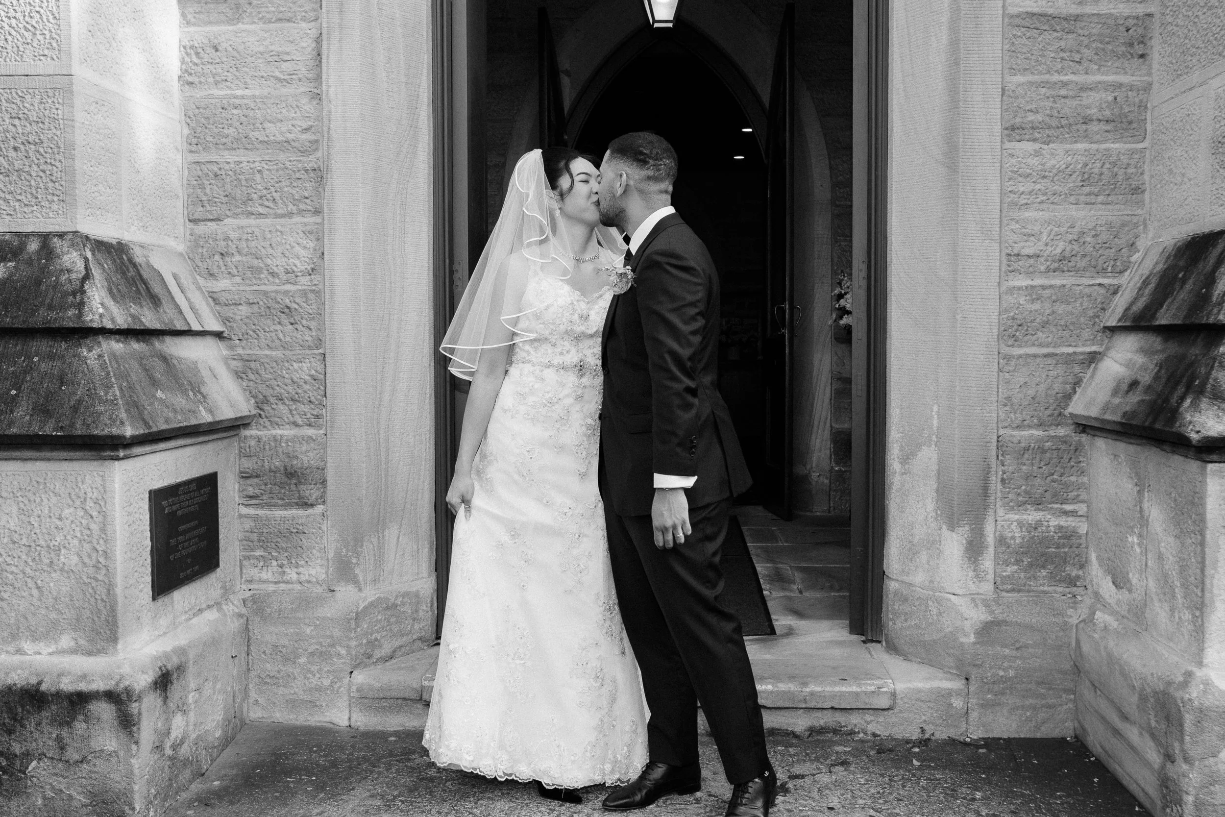 Married couple in Sydney church enjoying a first kiss.jpg