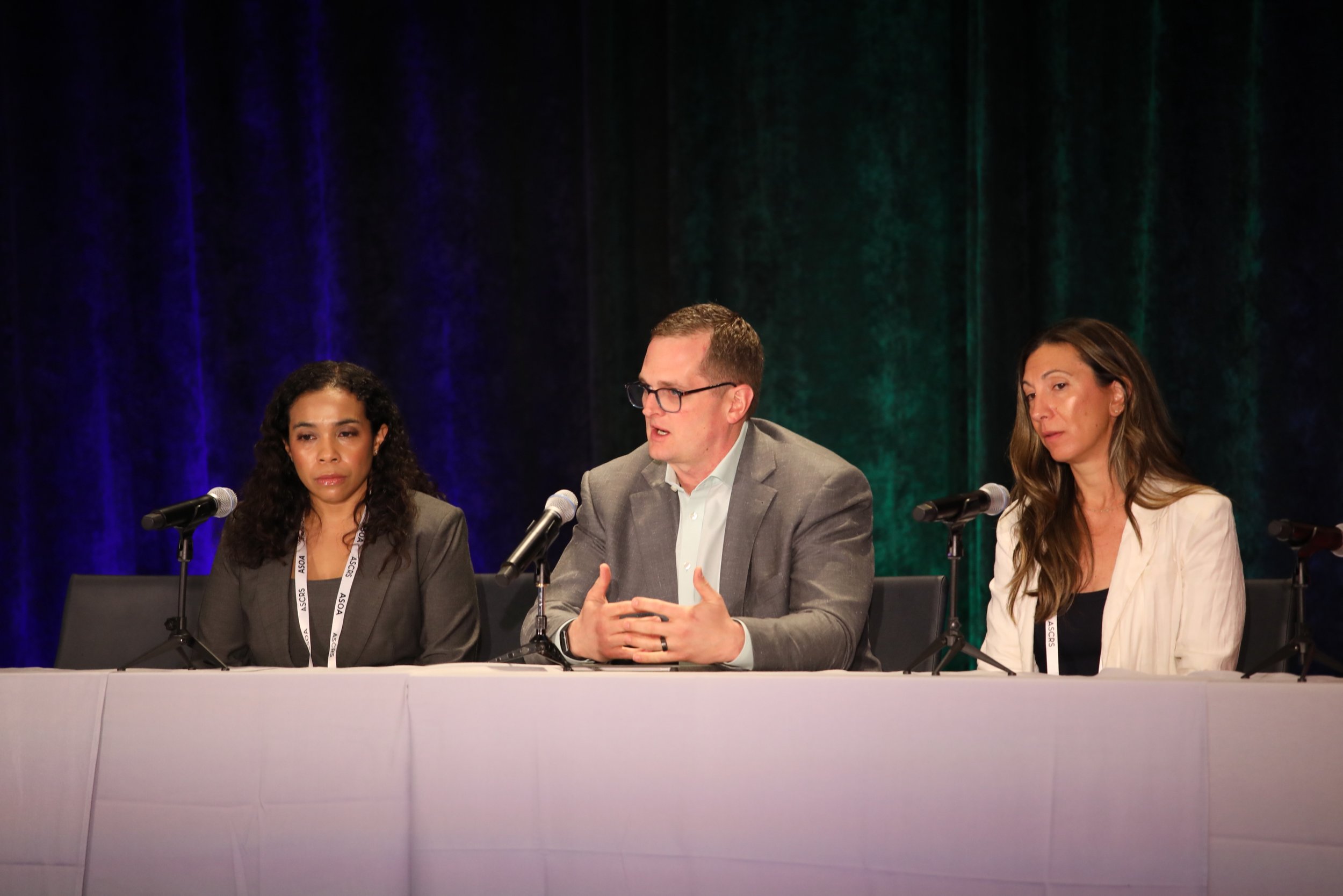 three business professionals including Founder & Managing Partner Ben Seals, talking on a panel in front of an audience