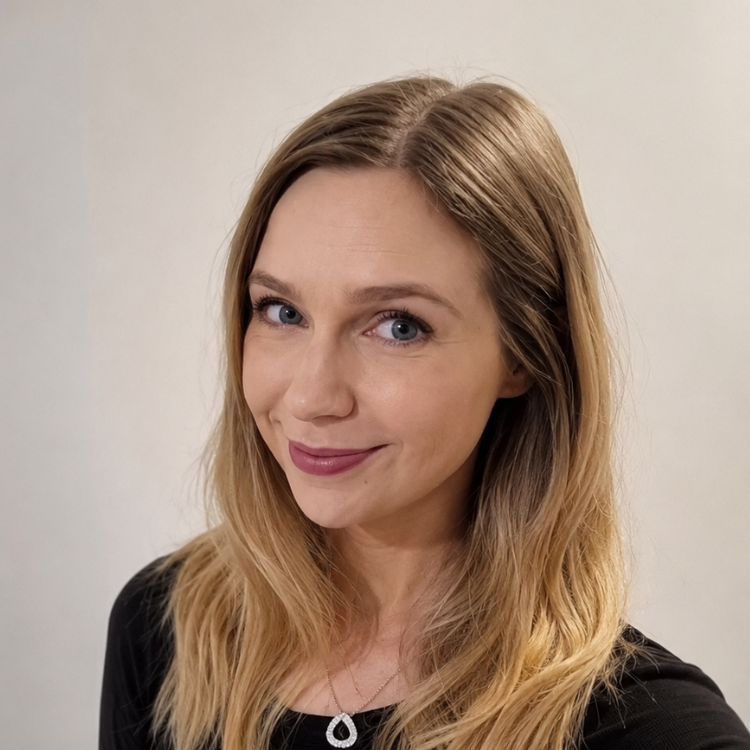 Instructor, Rachel Chapman, with long blonde hair and blue eyes smiling at the camera, wearing a black top against a white background.