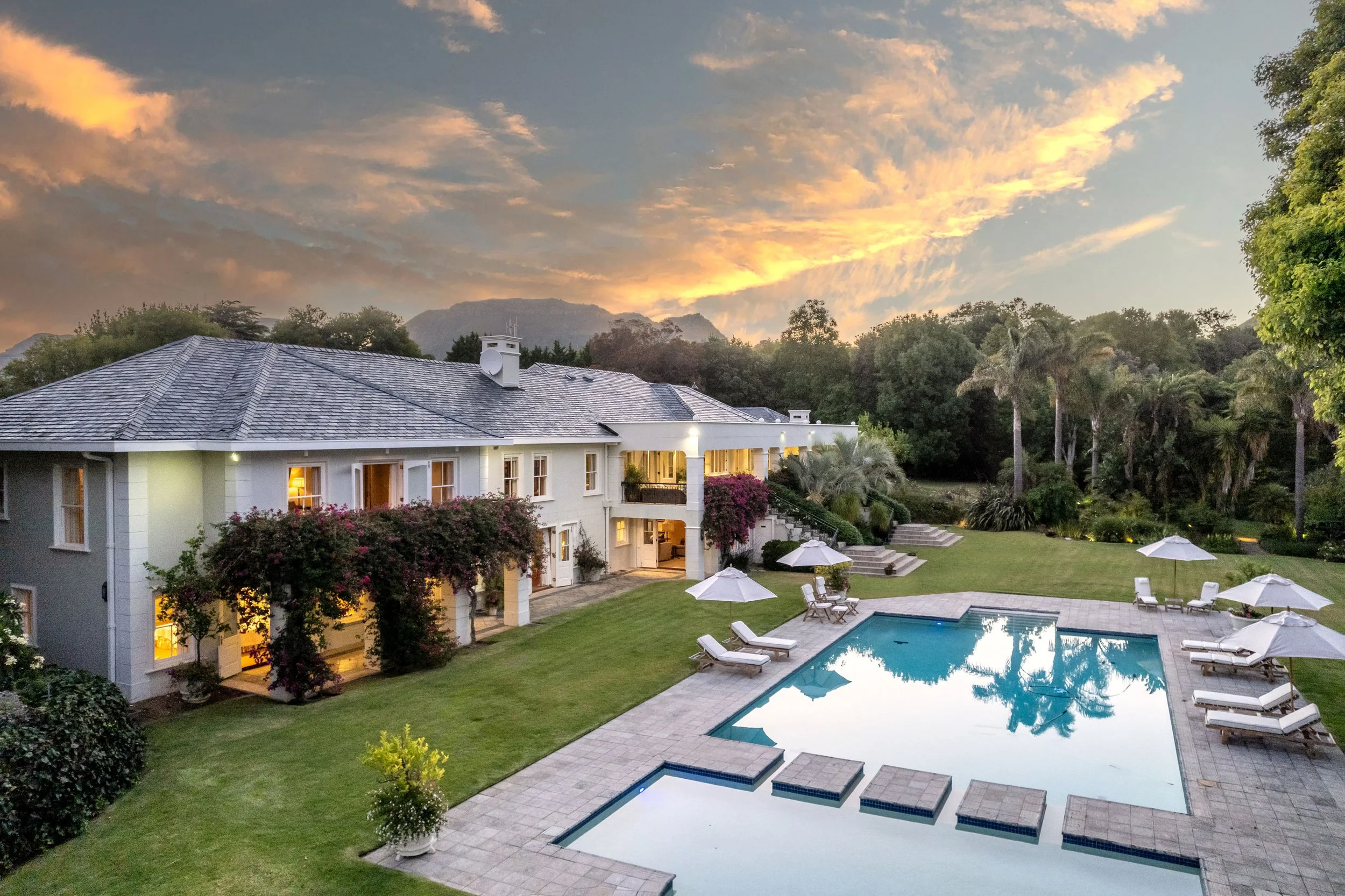 Luxury Moya Lux villa in Constantia with pool and gardens at sunset. Sleeps 14.