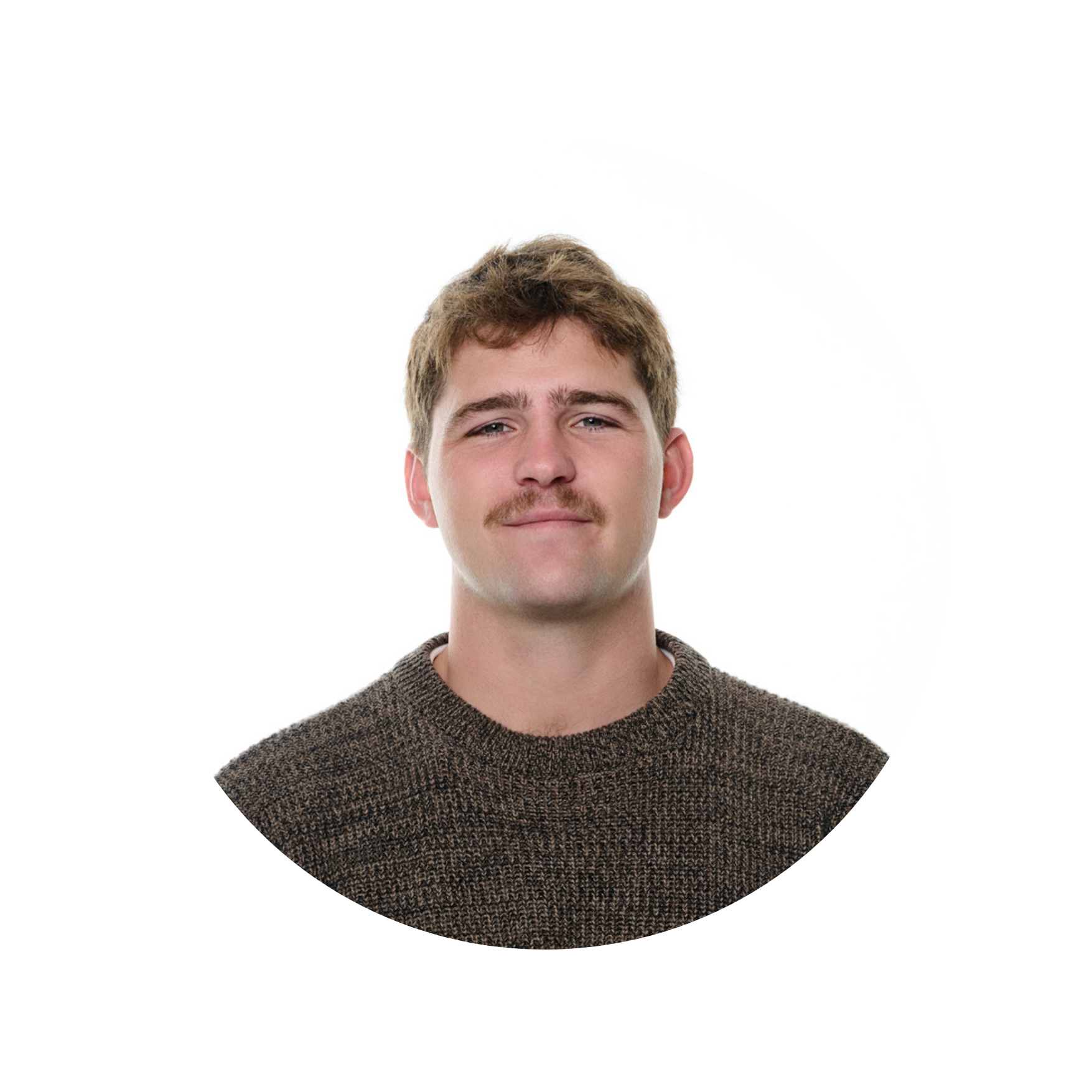 Portrait of a young man with light brown hair, light skin, blue eyes, and a mustache, wearing a brown textured sweater against a plain white background.