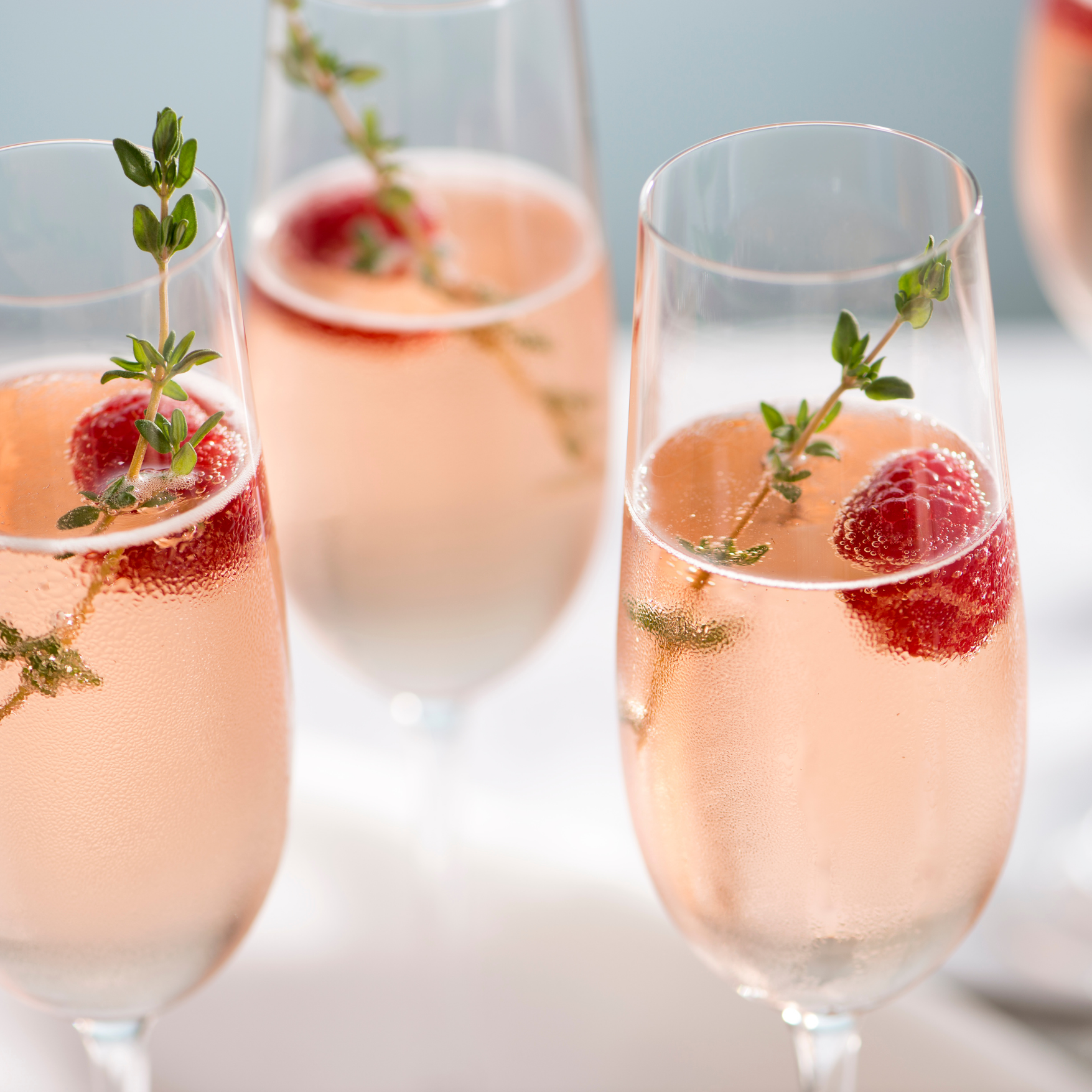 Pink sparkling drinks garnished with strawberries and thyme, set up for a private celebration in Cape Town.