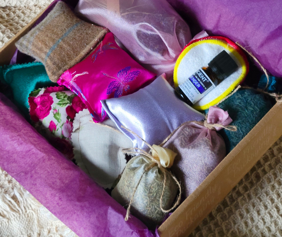 Brown cardboard activity box with purple tissue paper and lavender scented hearts, soothers and lavender filled organza bags inside