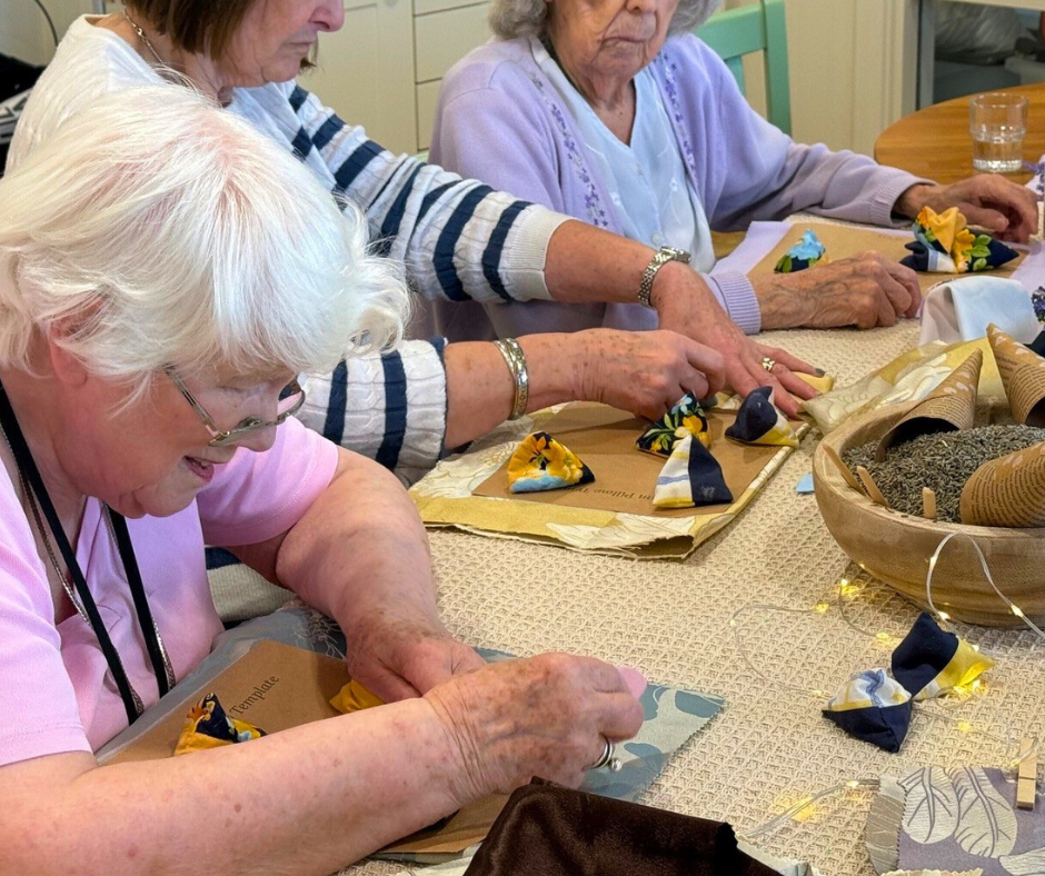 Table with three women sat engaged in a craft workshop
