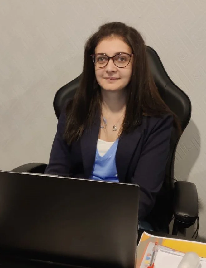 Professional online science tutor sitting at a desk with a laptop for personalised science lessons.