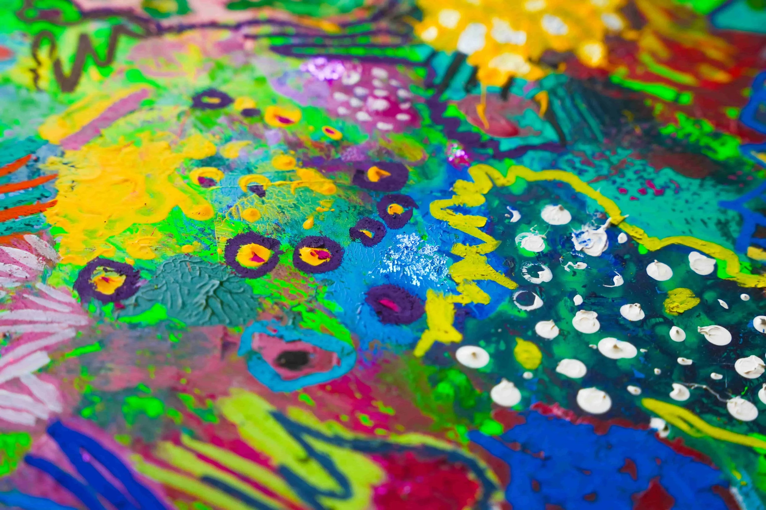 Detailed view of a colorful artwork, emphasizing the texture, color variations, and painting technique.