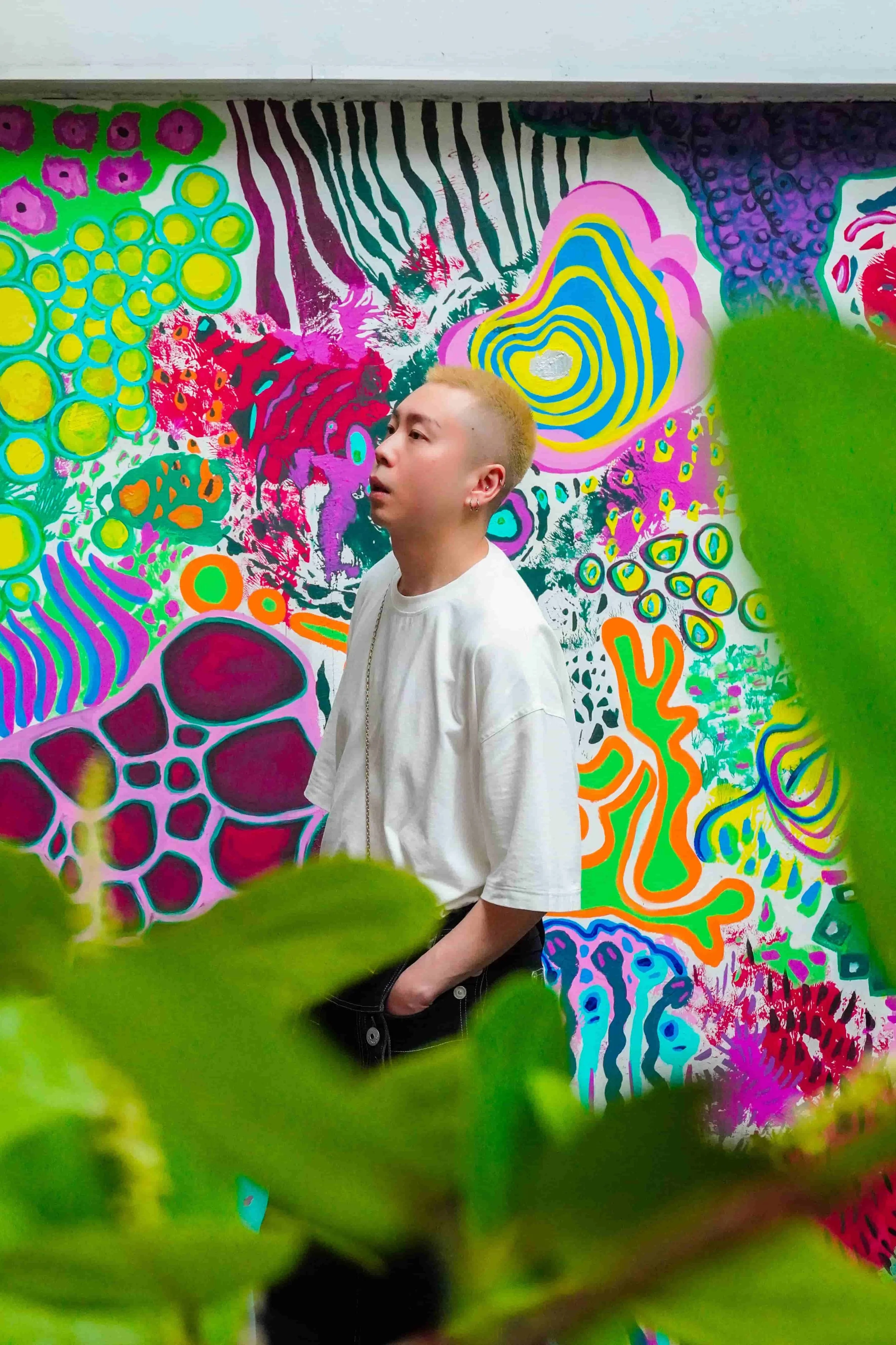 BIKUTAMALAMIA, portrait of HK based artist Peter Wu, he is in front of colourful bold & surreal mural, solo exhibition la premiere 2024