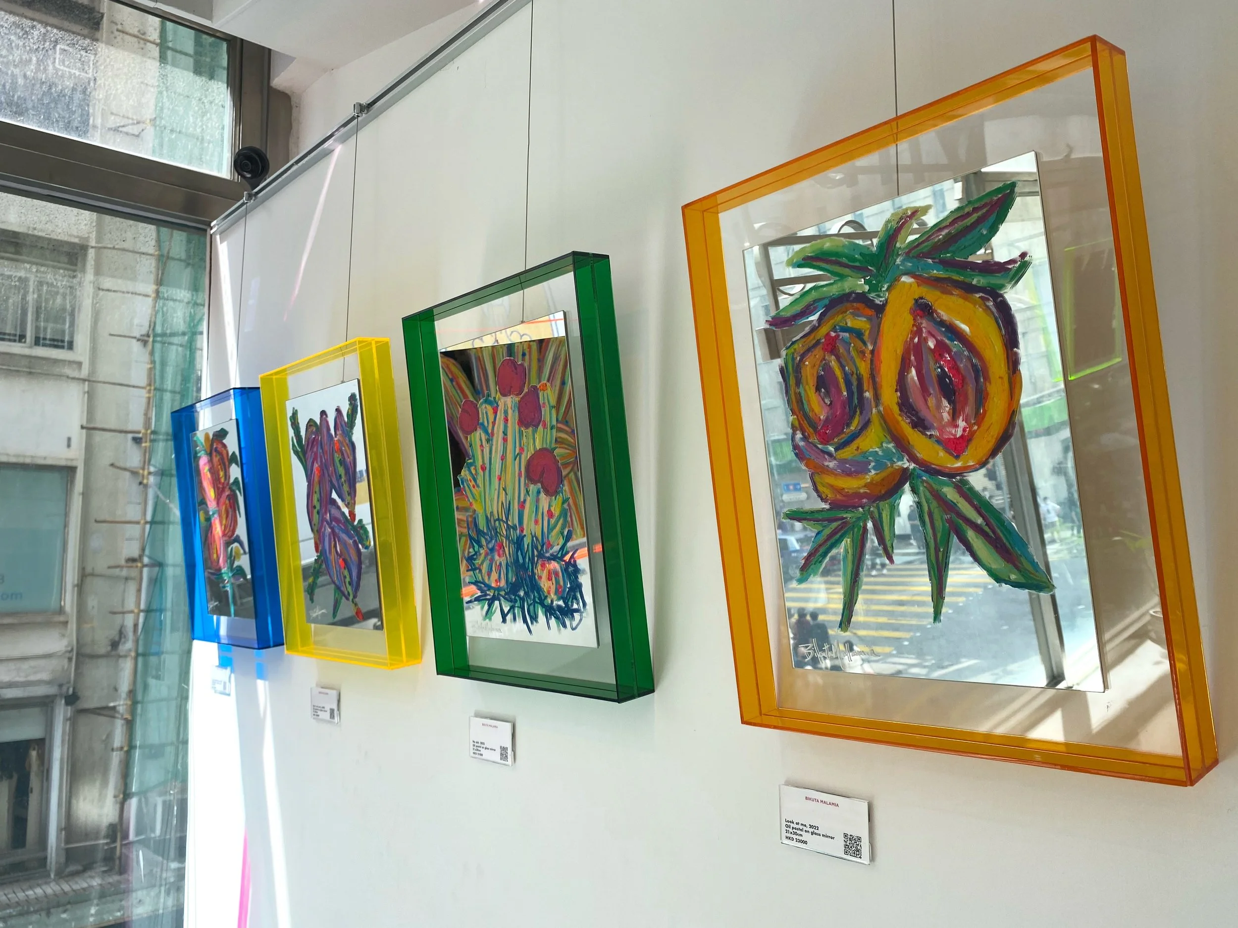 A wall displaying a collection of colorful framed art, contributing to a bright and joyful environment.