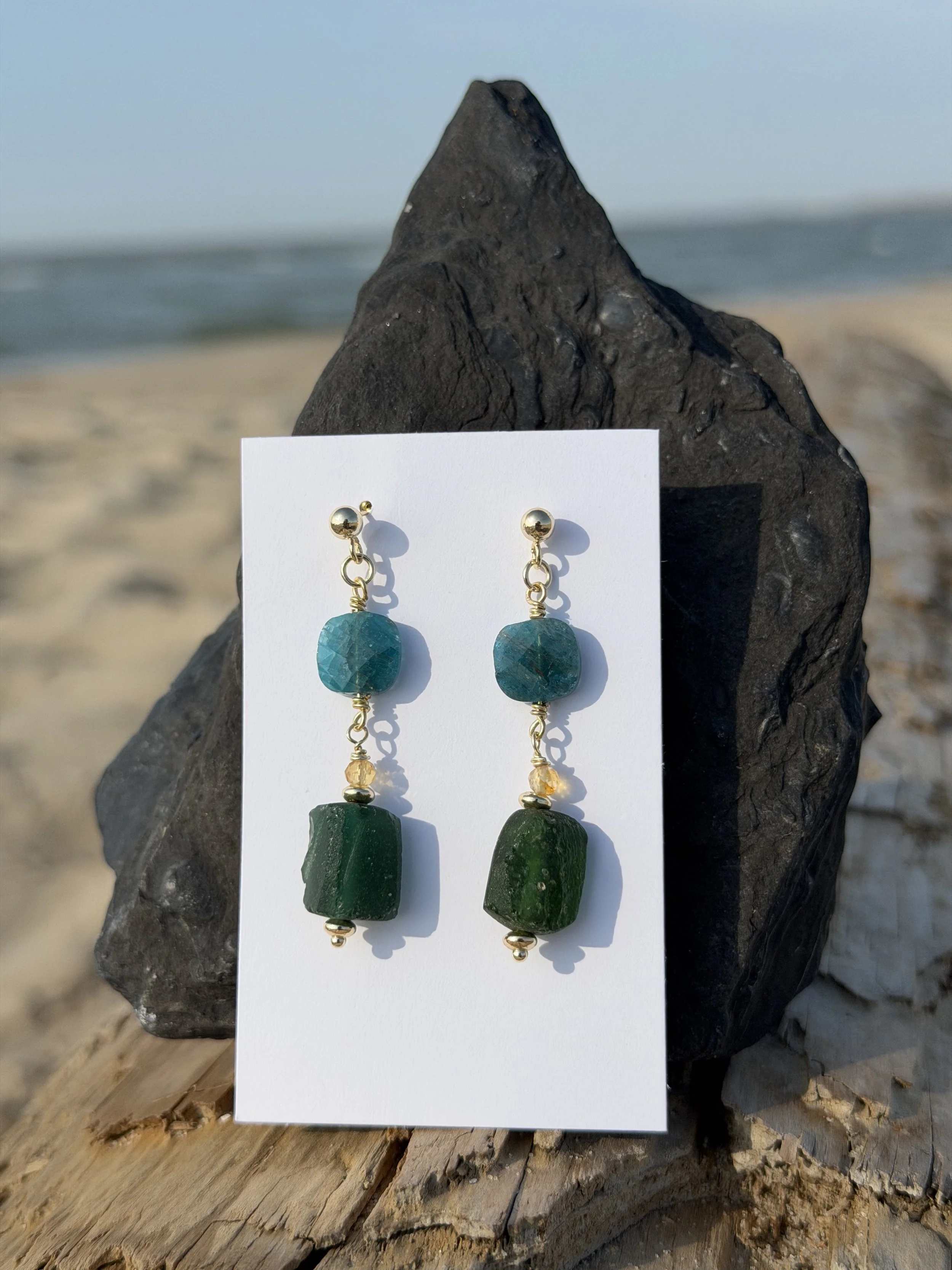 Handmade green gemstone drop earrings with irregular natural stones displayed outdoors.