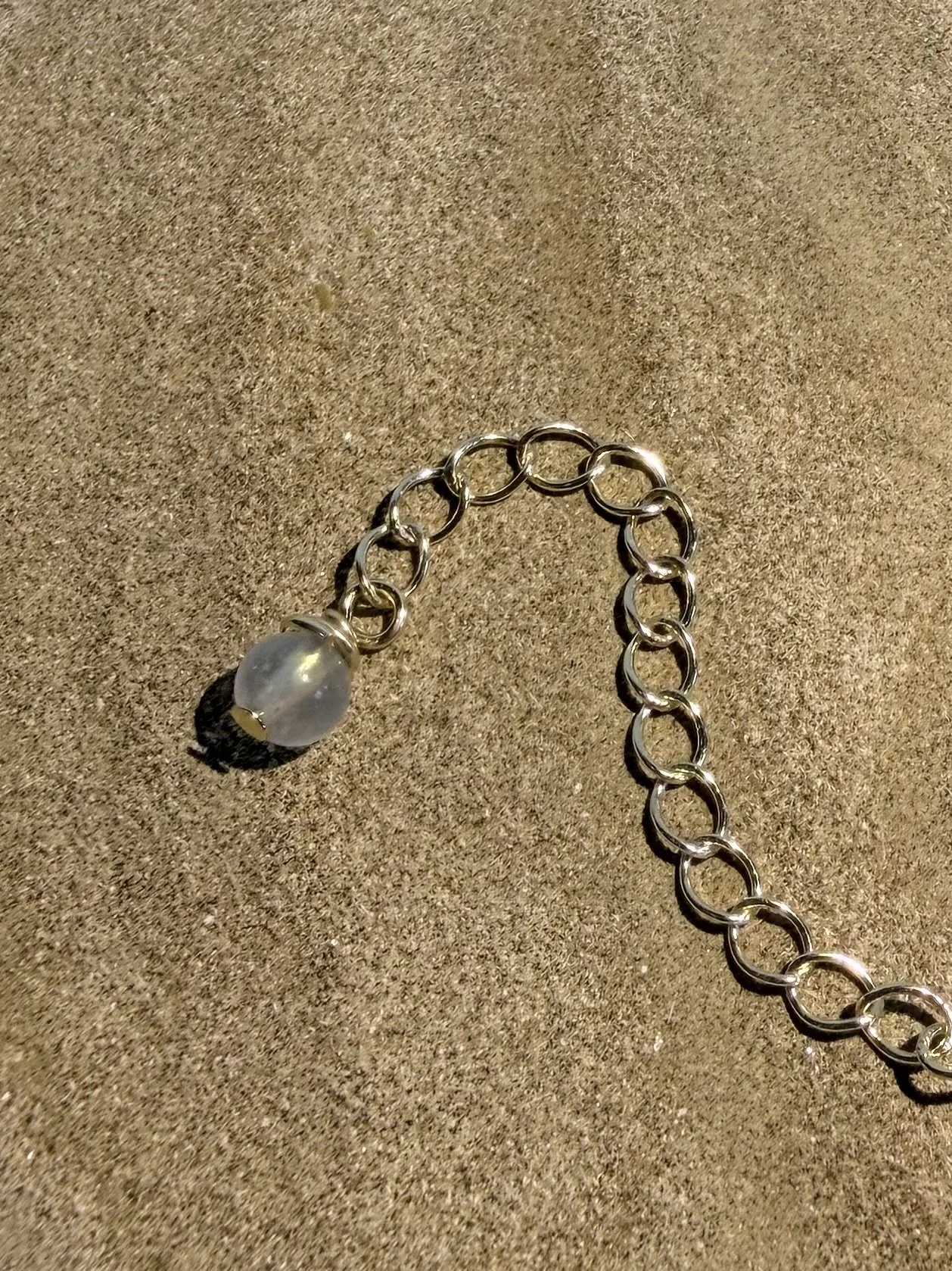 Close-up of the adjustable extender chain with gemstone detail on the handmade necklace.