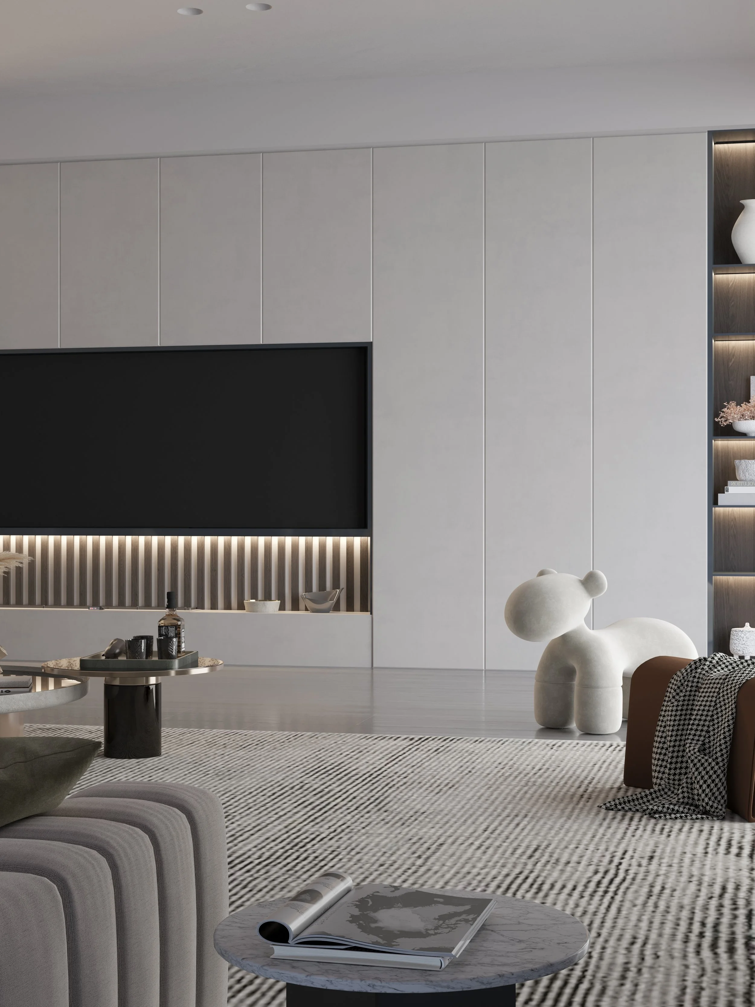 Modern living room with a gray and white color scheme, featuring a television, decorative shelves with vases and books, a large dog-shaped sculpture, a round marble coffee table with magazines, and a patterned rug.