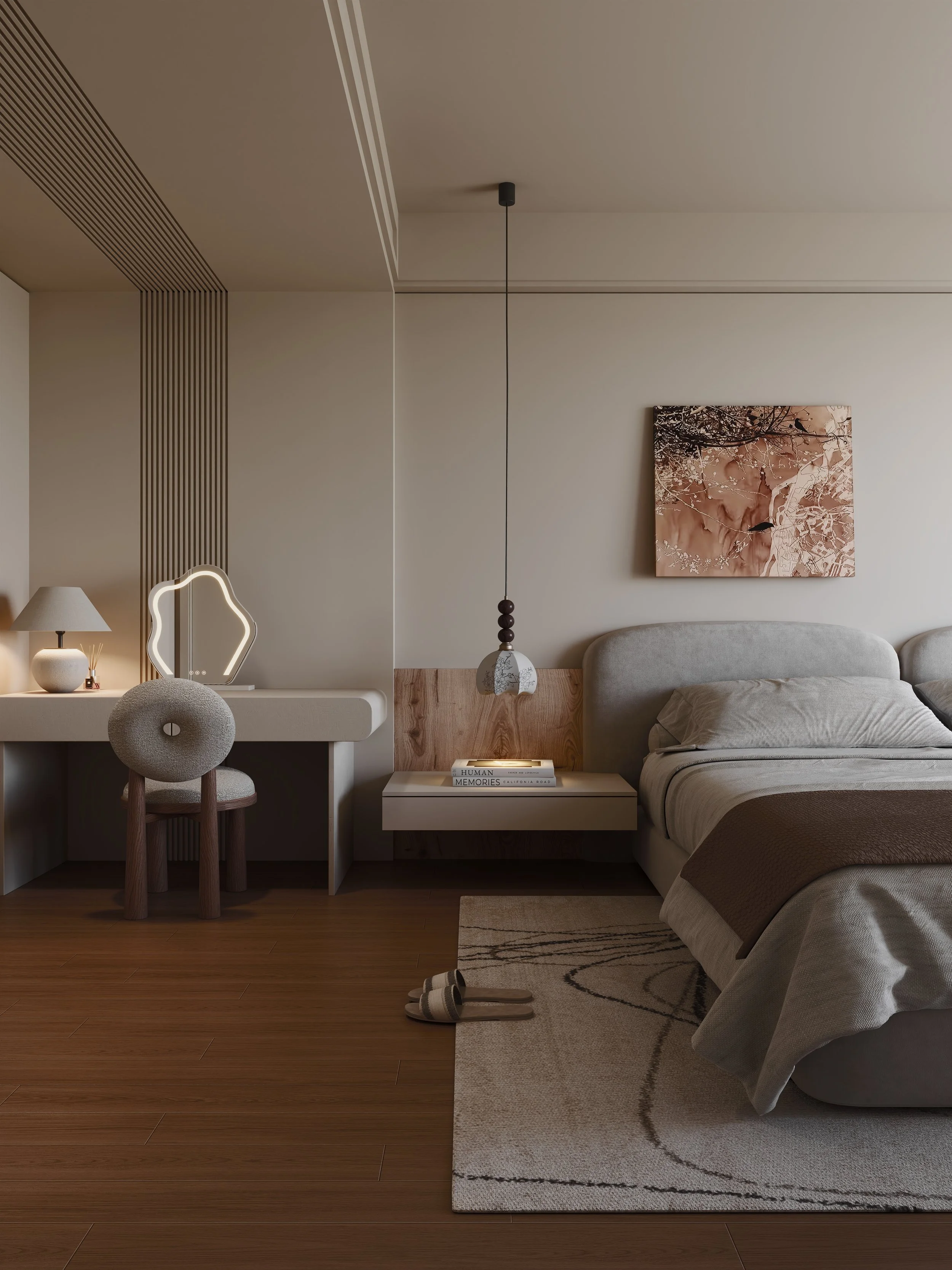 A modern bedroom with a bed, a nightstand with books, a hanging pendant light, wall art, a desk with a chair, a table lamp, and slippers on a rug on hardwood flooring.