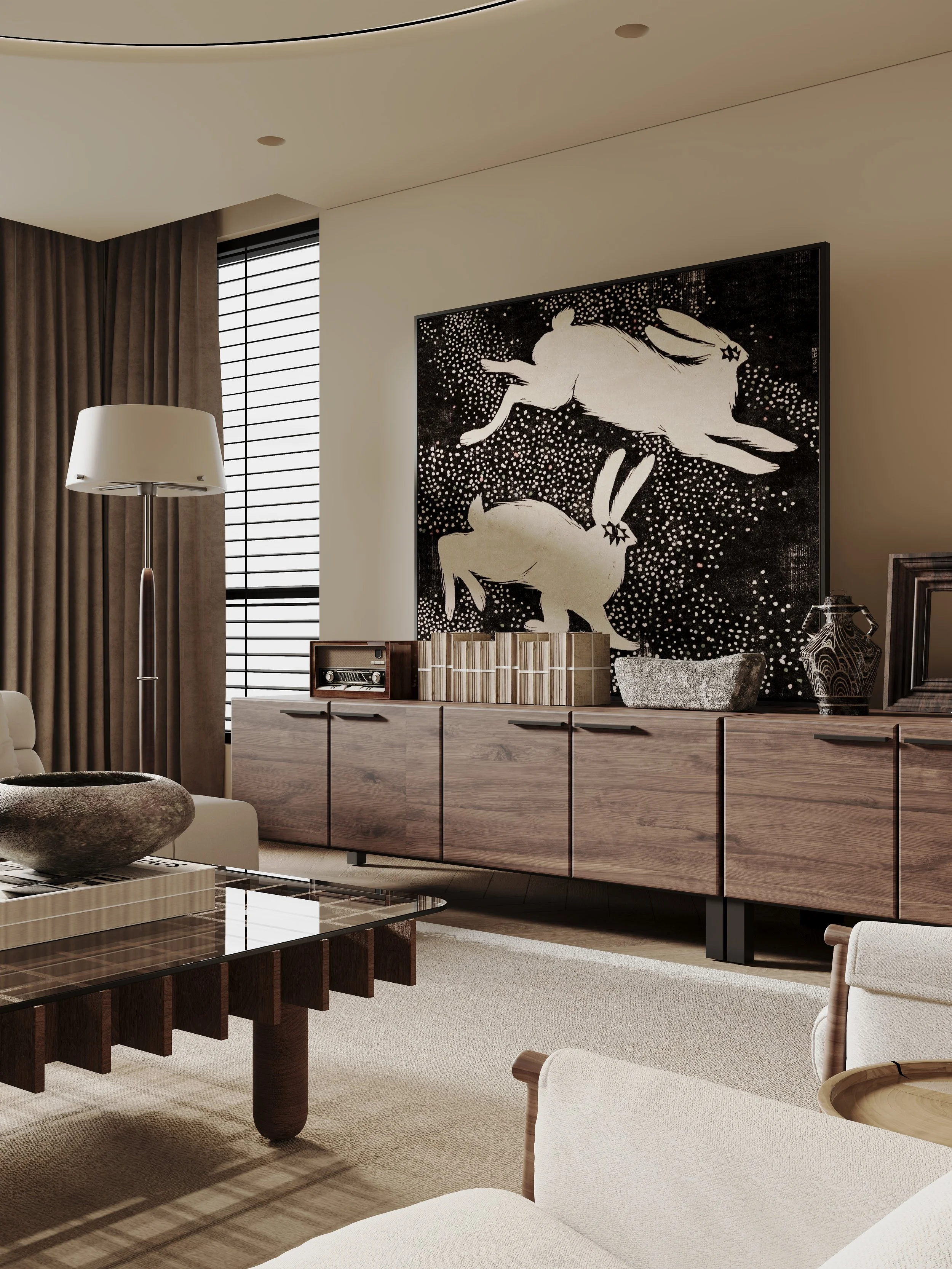 Modern living room with beige carpet, beige walls, large black and white artwork of two rearing horses, wooden sideboard, white armchair, glass coffee table with a decorative bowl, floor lamp, closed window with black blinds, brown curtains.