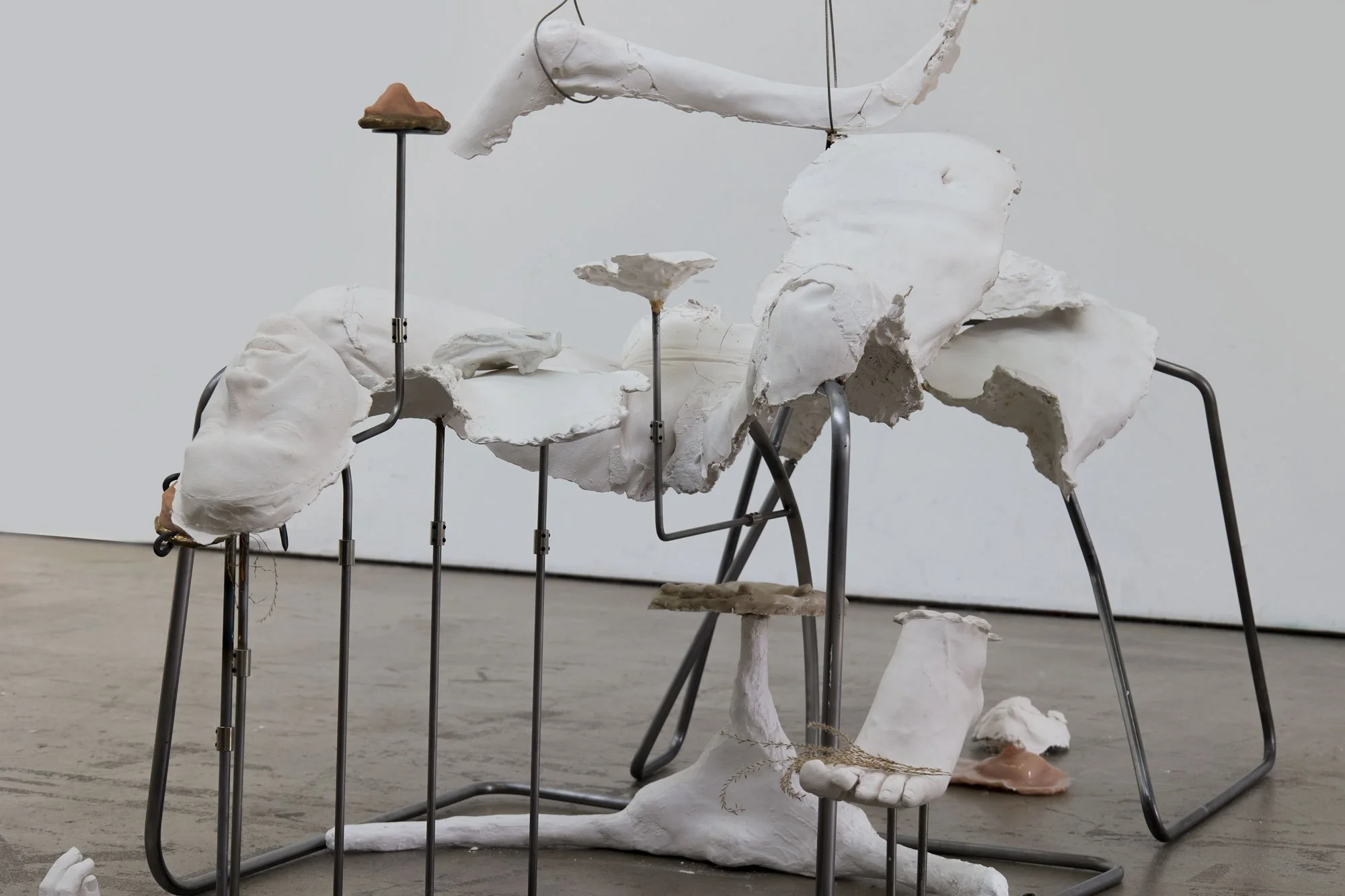 'Not So Very Far Off Lie More Ruins' (2026) | Plaster, silicone, bronze, steel, car suspension arms, steel cord, dried plants, wig | 200 x 100 x 350cm