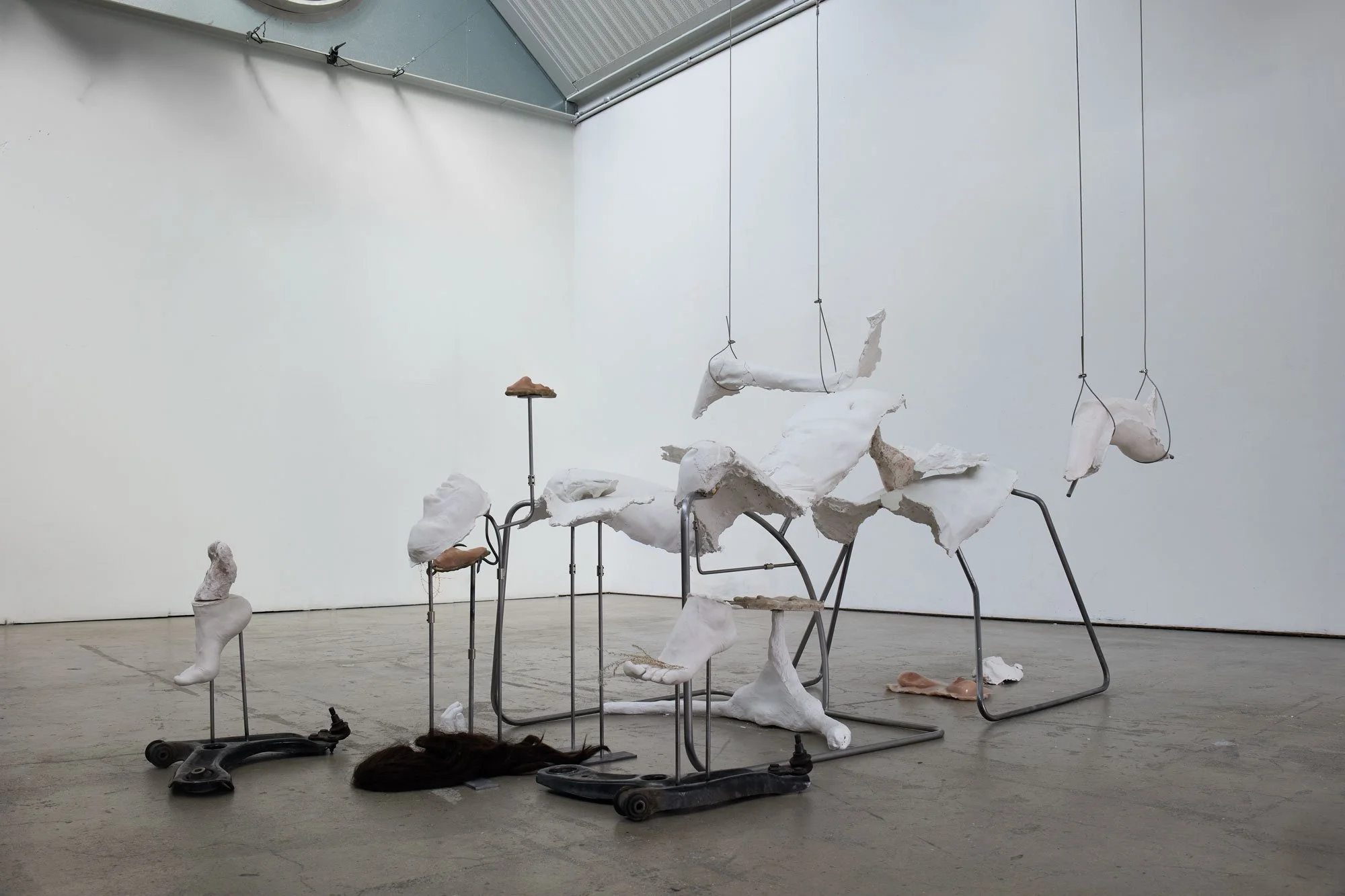 'Not So Very Far Off Lie More Ruins' (2026) | Plaster, silicone, bronze, steel, car suspension arms, steel cord, dried plants, wig | 200 x 100 x 350cm