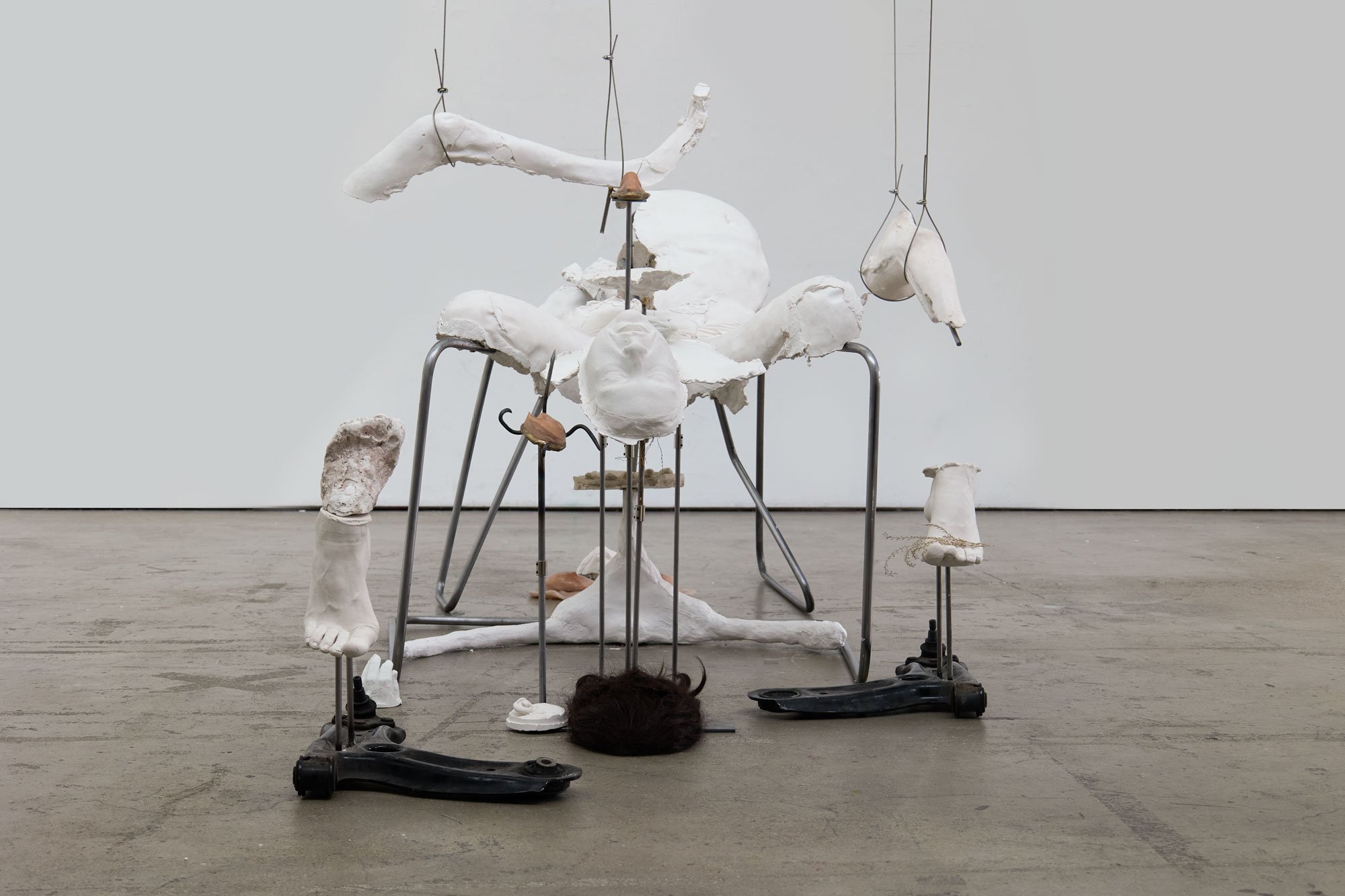 'Not So Very Far Off Lie More Ruins' (2026) | Plaster, silicone, bronze, steel, car suspension arms, steel cord, dried plants, wig | 200 x 100 x 350cm