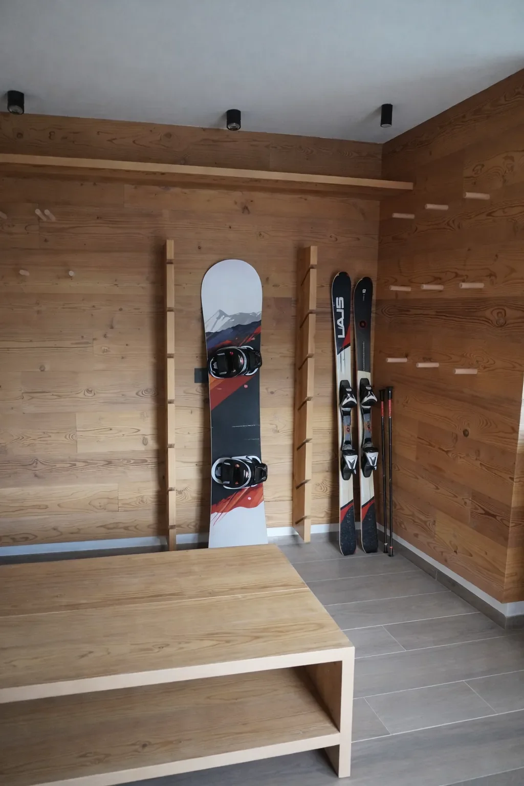 Attrezzature da sci e snowboard nell'armadietto di una cabina in legno.