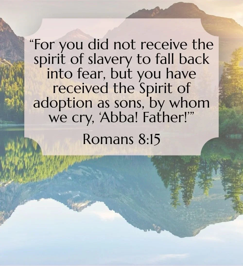 A scenic landscape with mountains, trees, and a body of water, overlaid with a Bible verse from Romans 8:15.