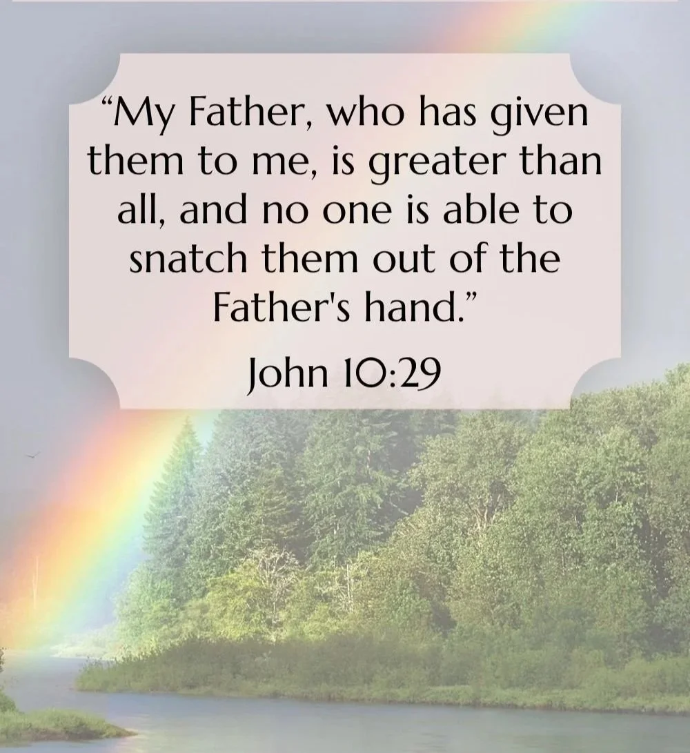 A nature scene with a rainbow over a river and green trees, featuring a biblical quote from John 10:29.