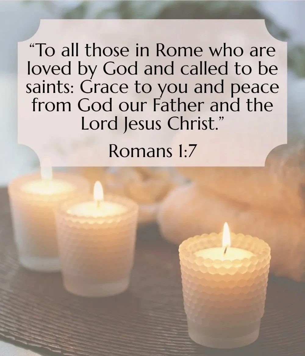 Lit candles surrounding a quote from Romans 1:7 about loved ones in Rome called to be saints, with a blurred background.
