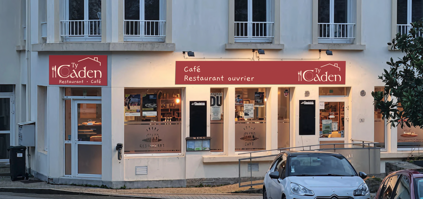 Extérieur d'un restaurant nommé Ty Caden avec enseignes en français, vitres et voitures garées devant.