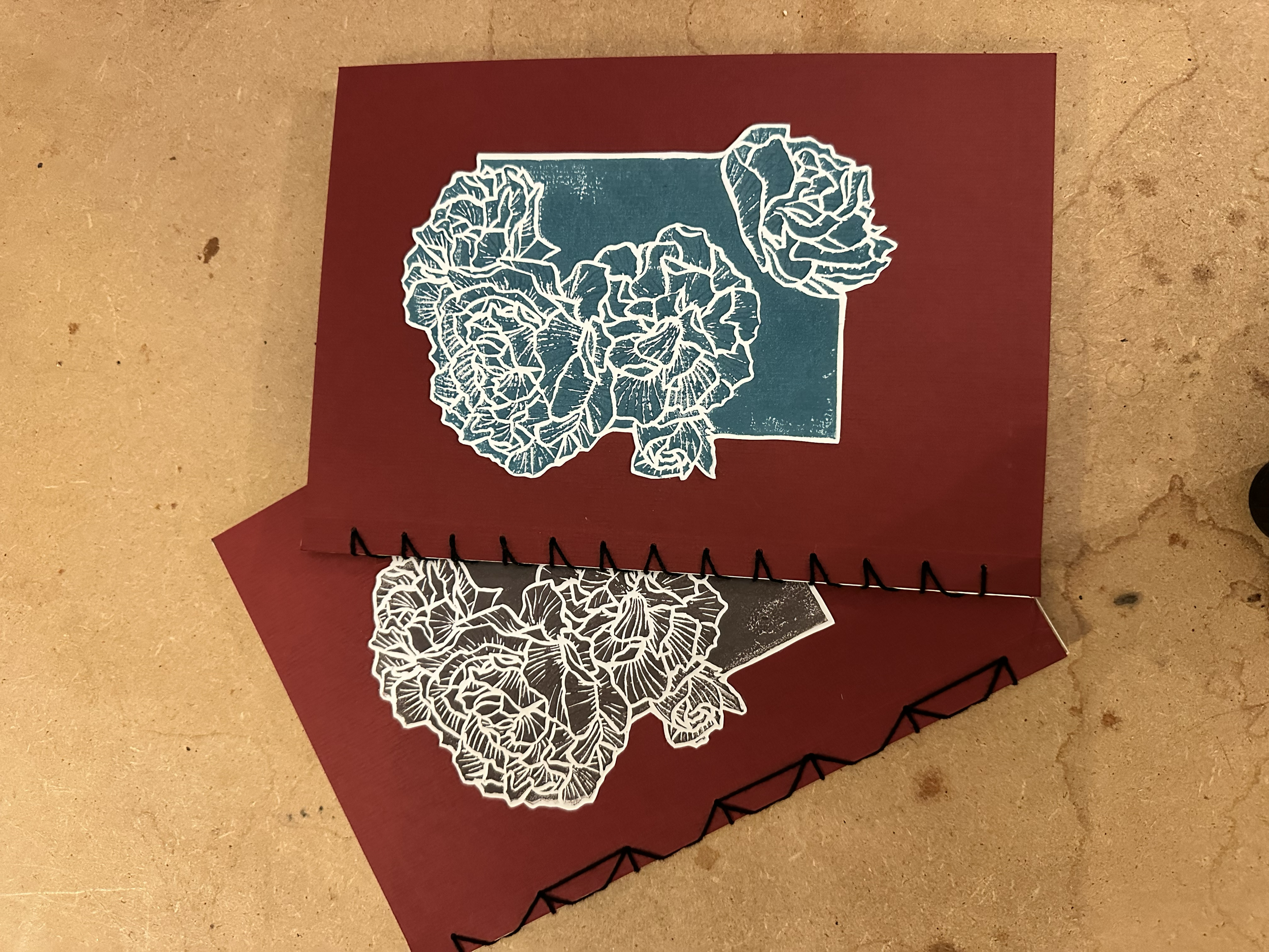 Carnets rouges avec des illustrations en linogravure de fleurs.