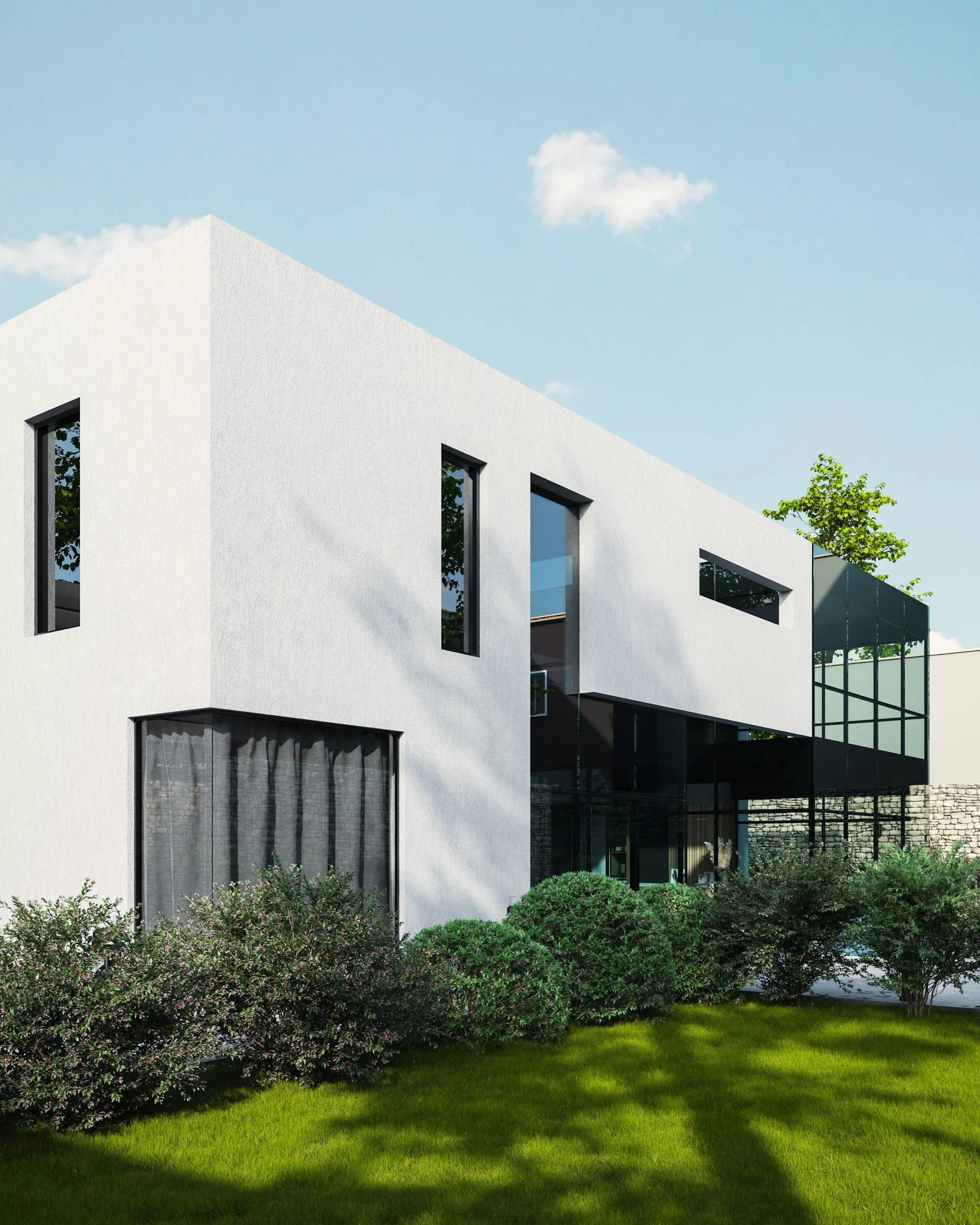 Modern white building with rectangular windows, surrounded by green lawn and bushes, under a blue sky with a few clouds.
