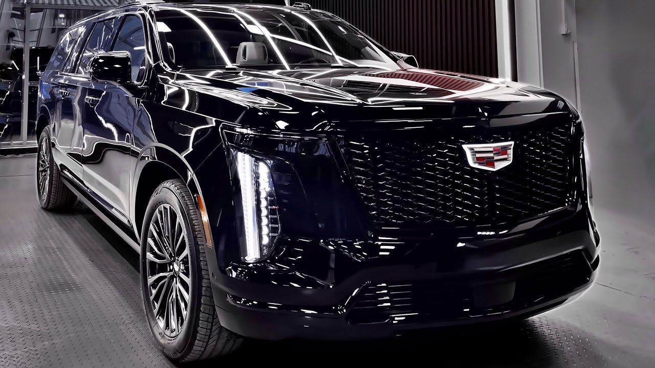 Black Cadillac SUV with chrome grille in a showroom.