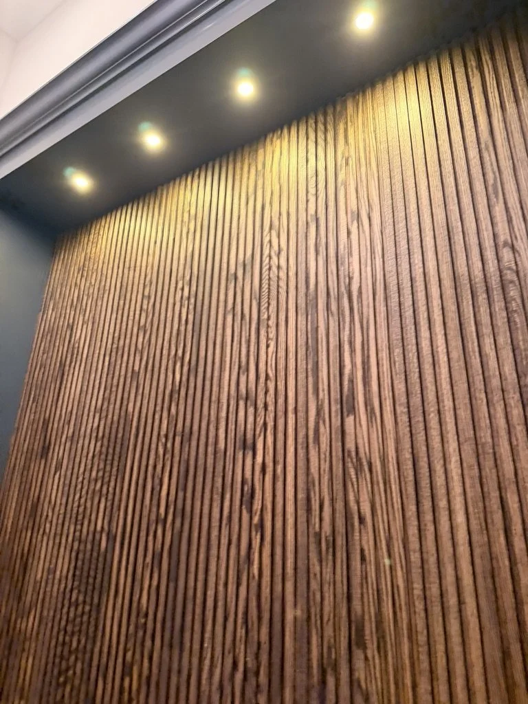 Wooden slat wall with built-in ceiling lights.