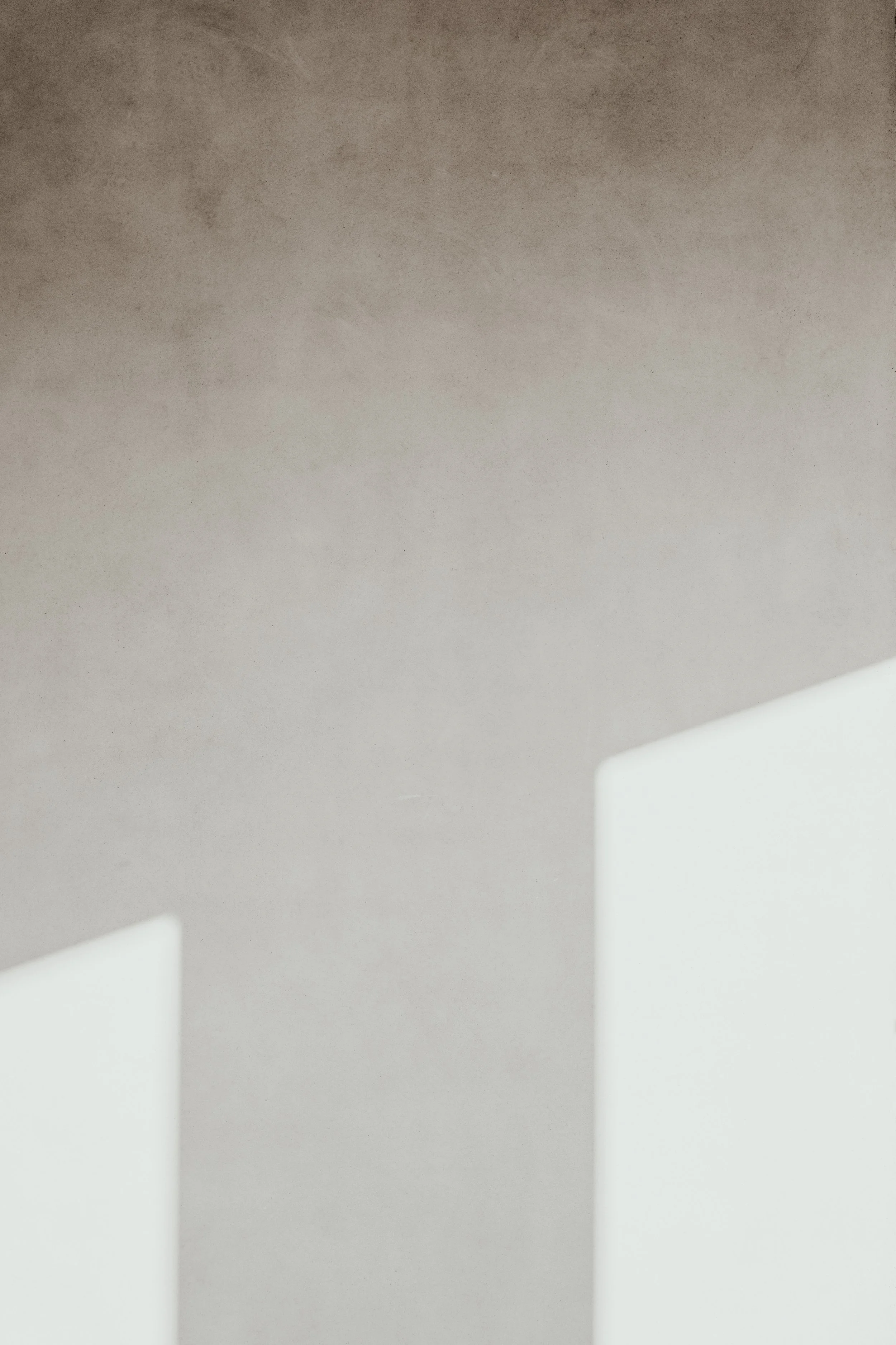 Close-up of white sheets or panels with circular cutouts, against a light gray background.