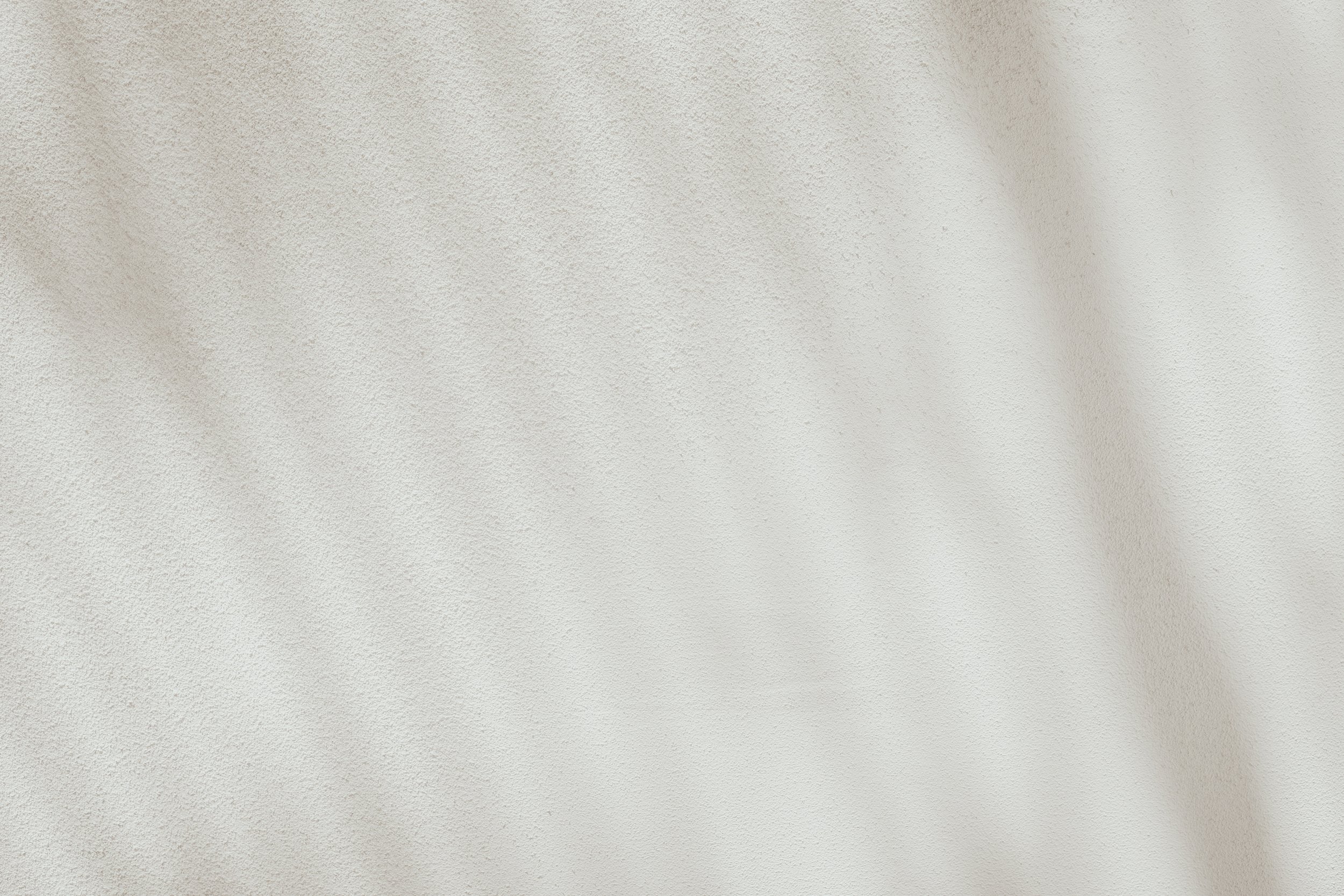 Plain white textured wall with no objects or features.
