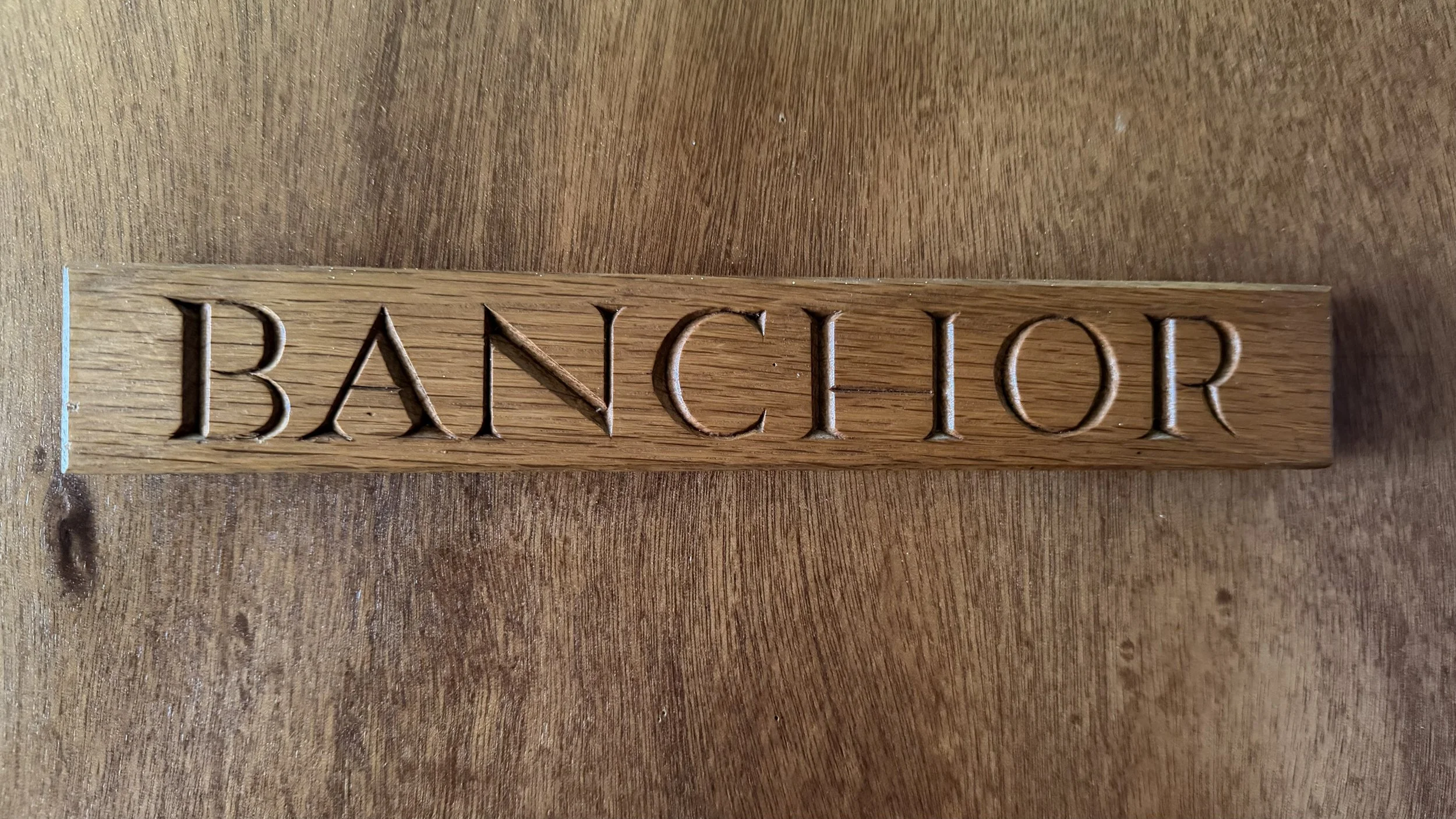Carved wooden 'BANCHOR' sign at Newtonmore Hostel — Banchor is one of the three Cairngorms-named rooms