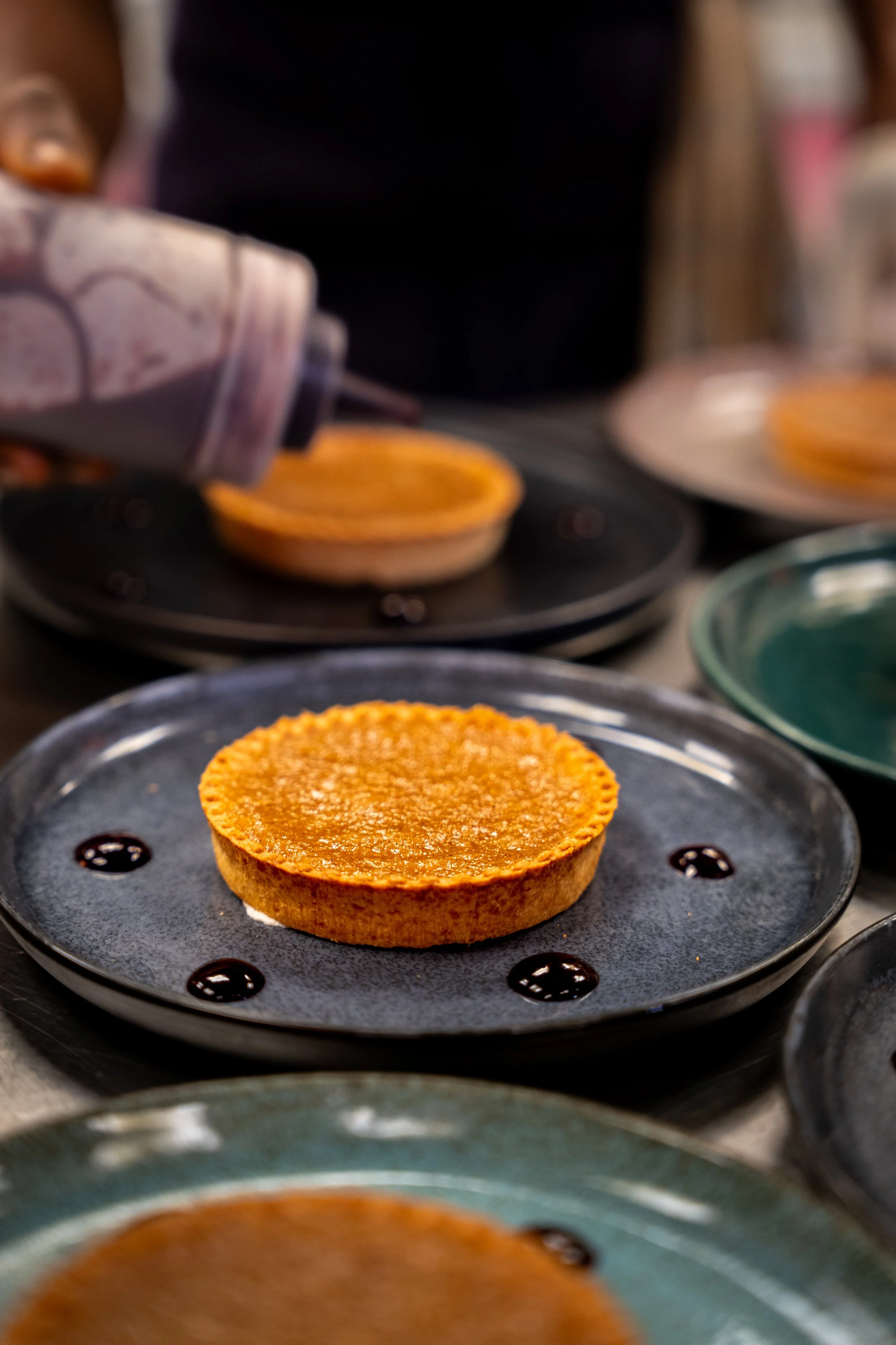 Préparation de tartelettes aux ingrédients colorés sur un plateau.
